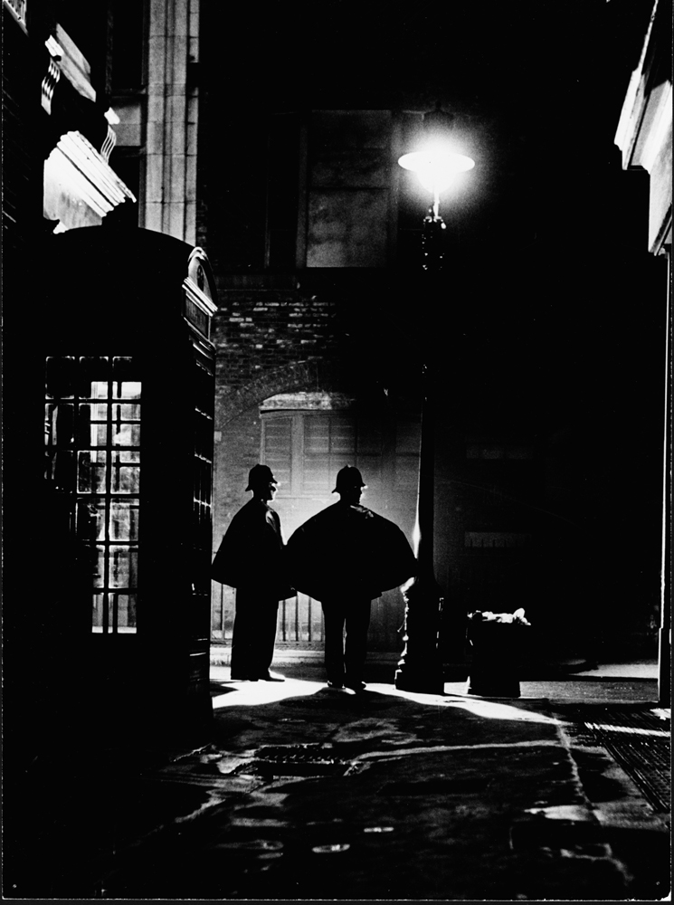 Policemen (sergeant and constable) from Scotland Yard patrol a street at night, 1946.