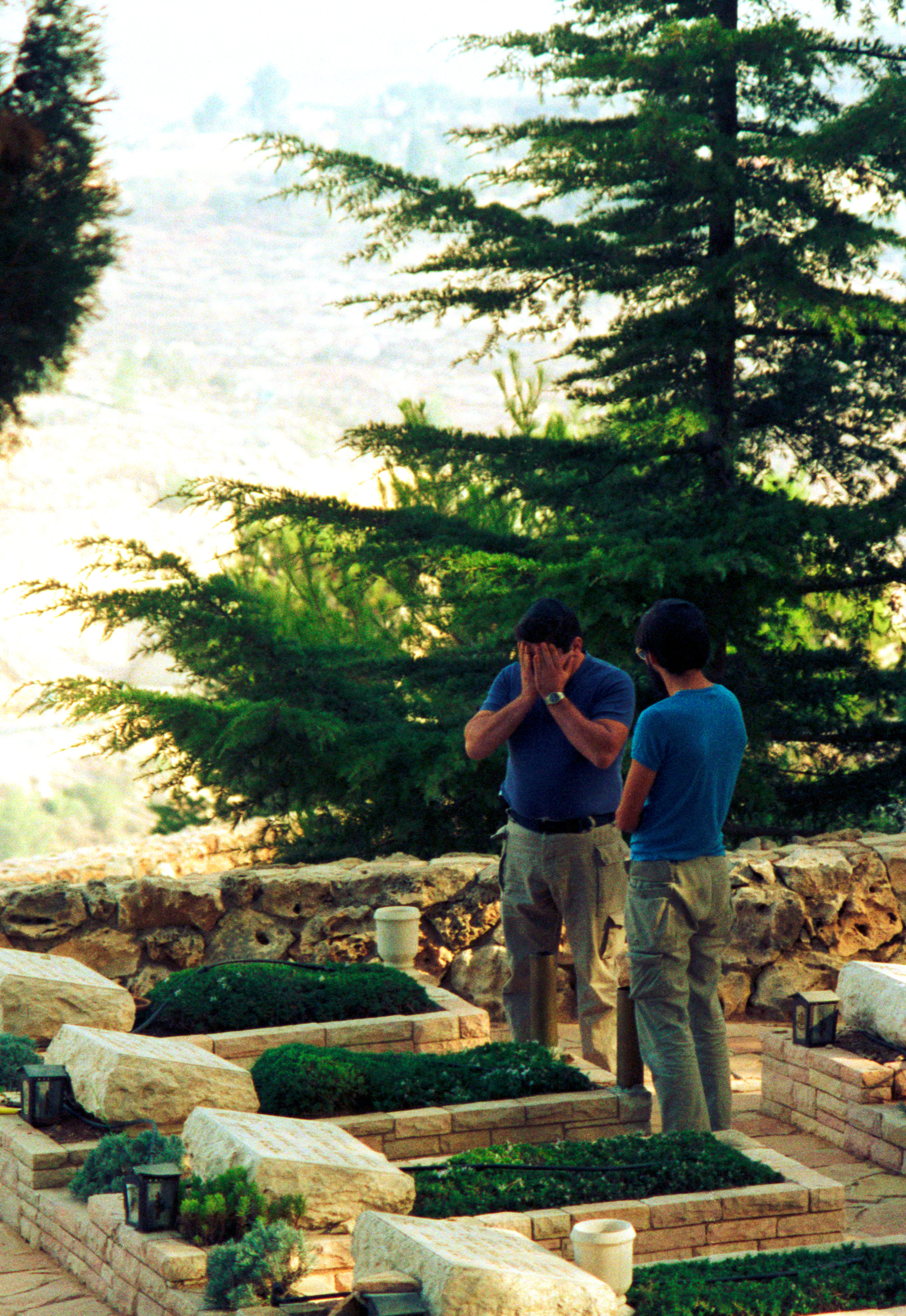 Commander Amedi, at left, takes a new member of the Jerusalem bomb squad to the military section of a cemetery overlooking the city to visit the grave of a bomb disposal officer who gave his life to a bomb.