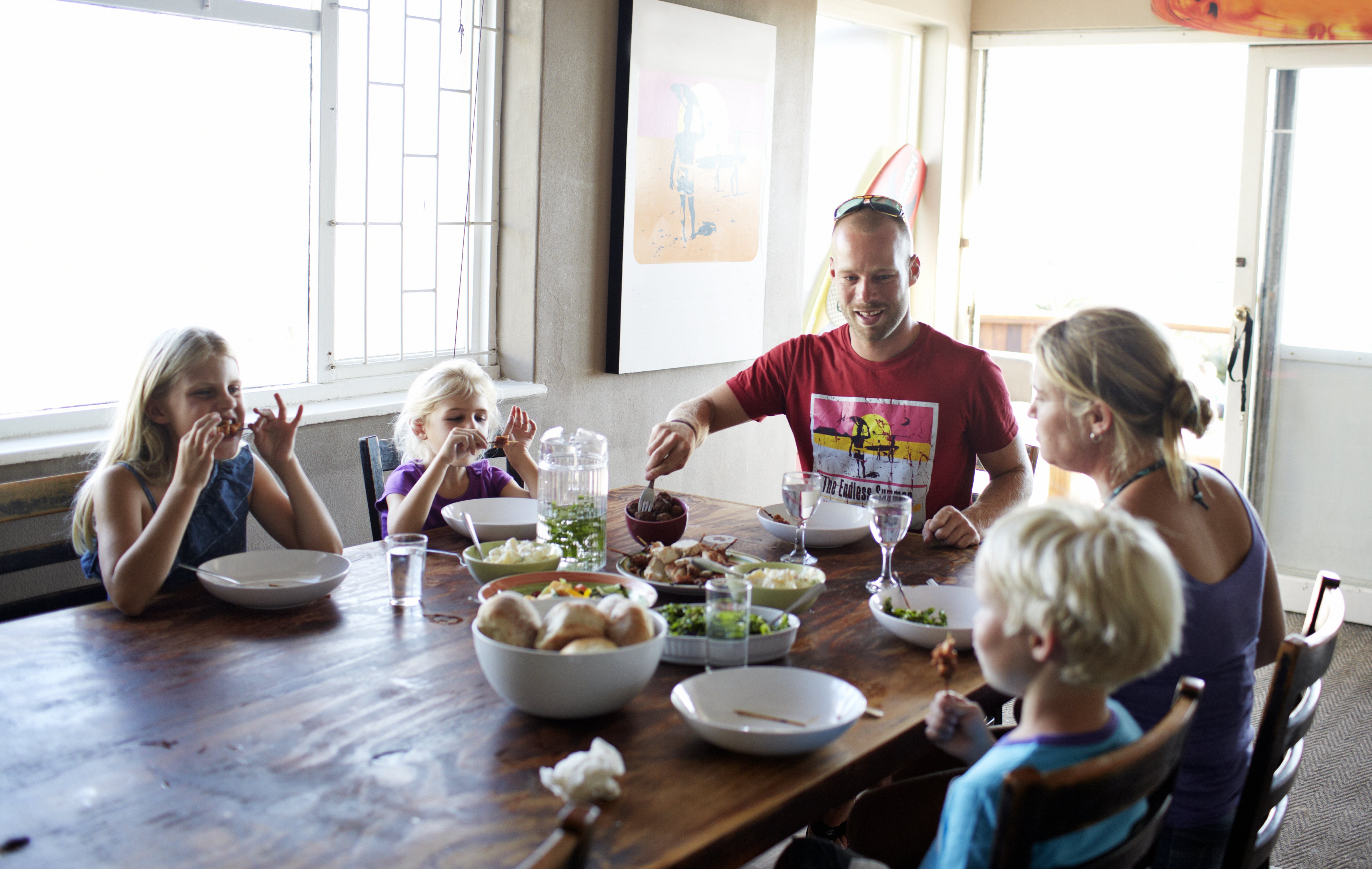 Happy family dinner images like this may be doing more harm than good for working families (Klaus Vedfelt—Getty Images)