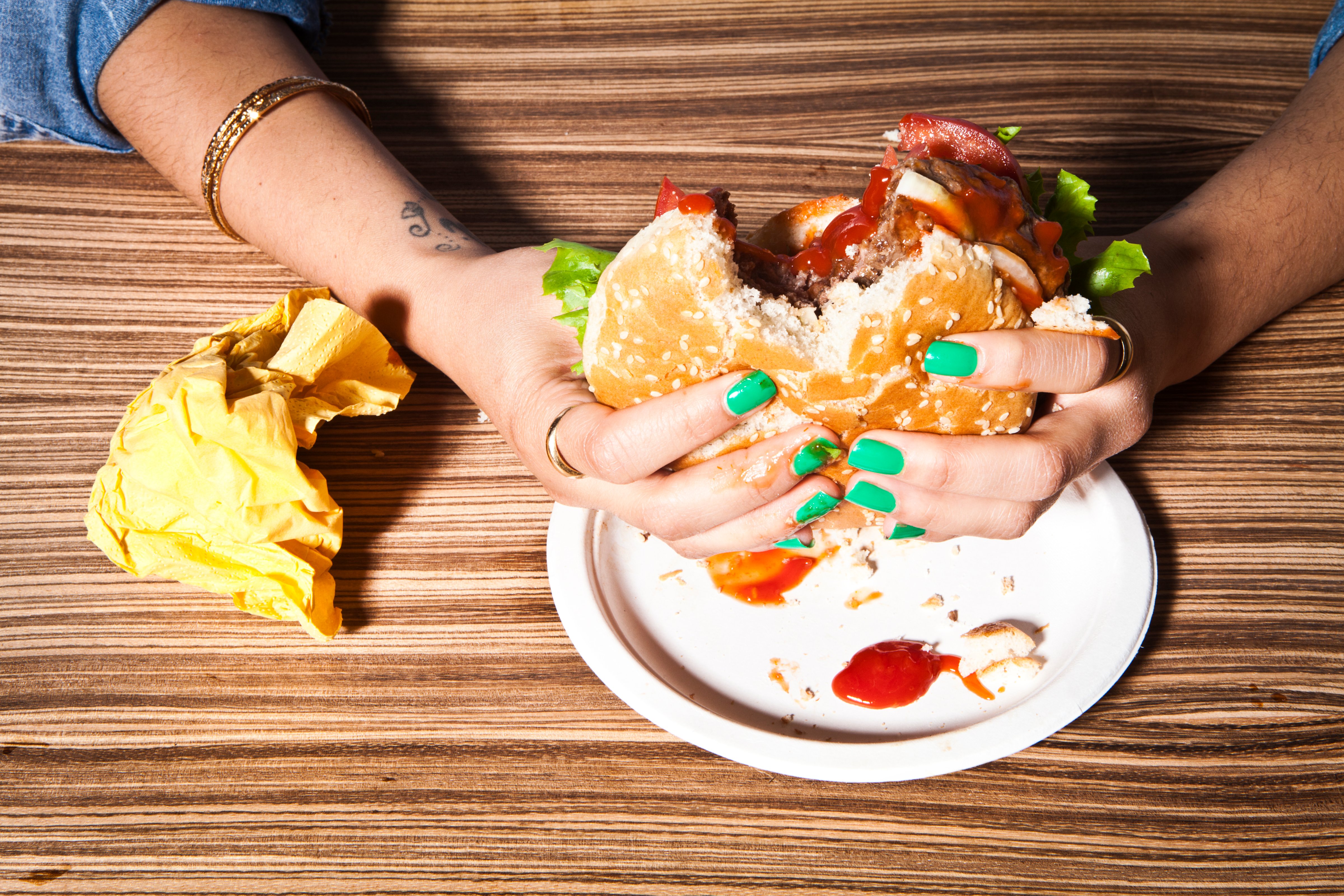 Woman's hands on a burger. (Dean Belcher—Getty Images)