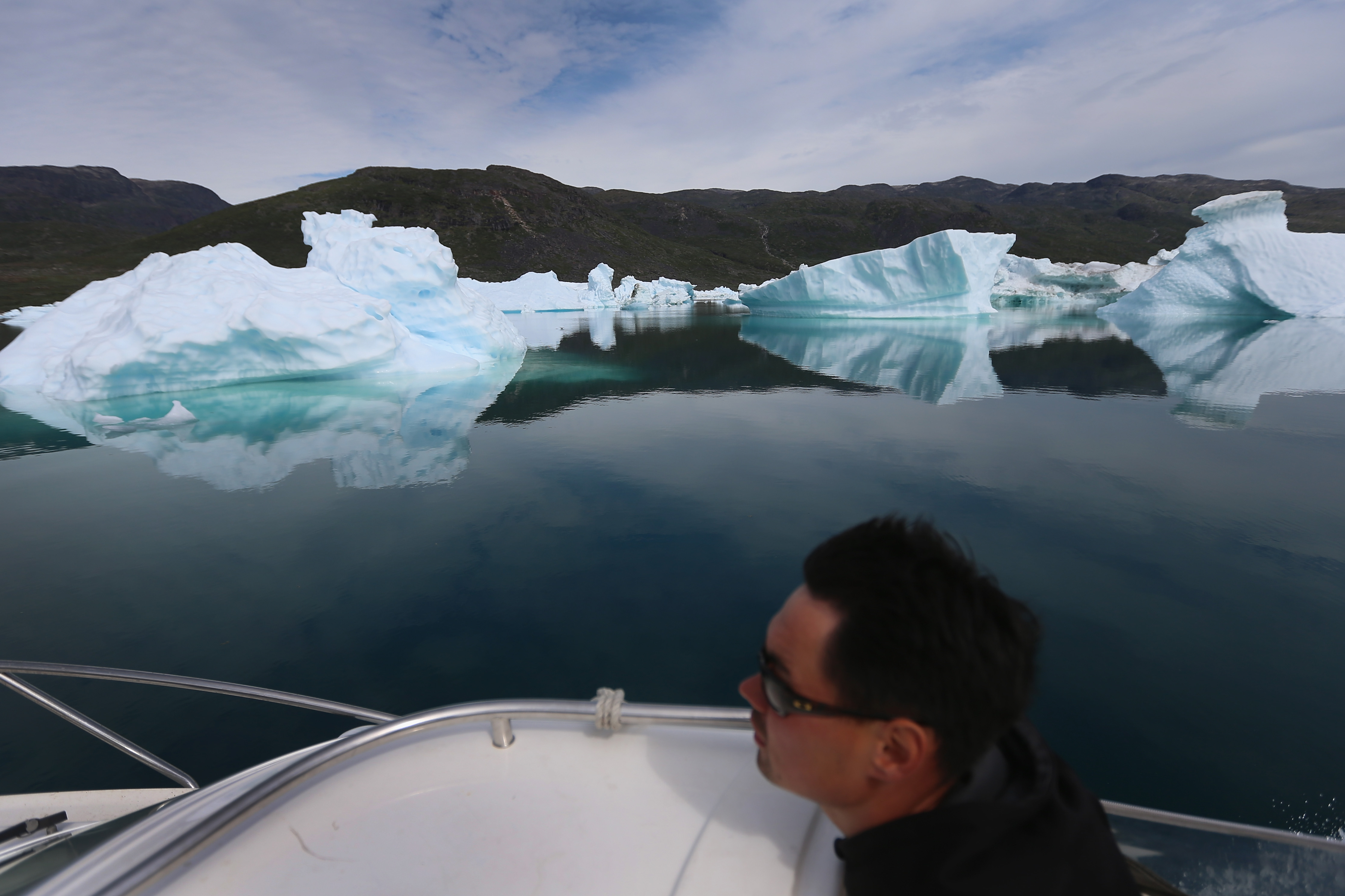 Kunuk Nielsen navigates his boat among calved icebergs from the nearby Twin Glaciers on July 31, 2013 in Qaqortoq, Greenland. (Joe Raedle—Getty Images)