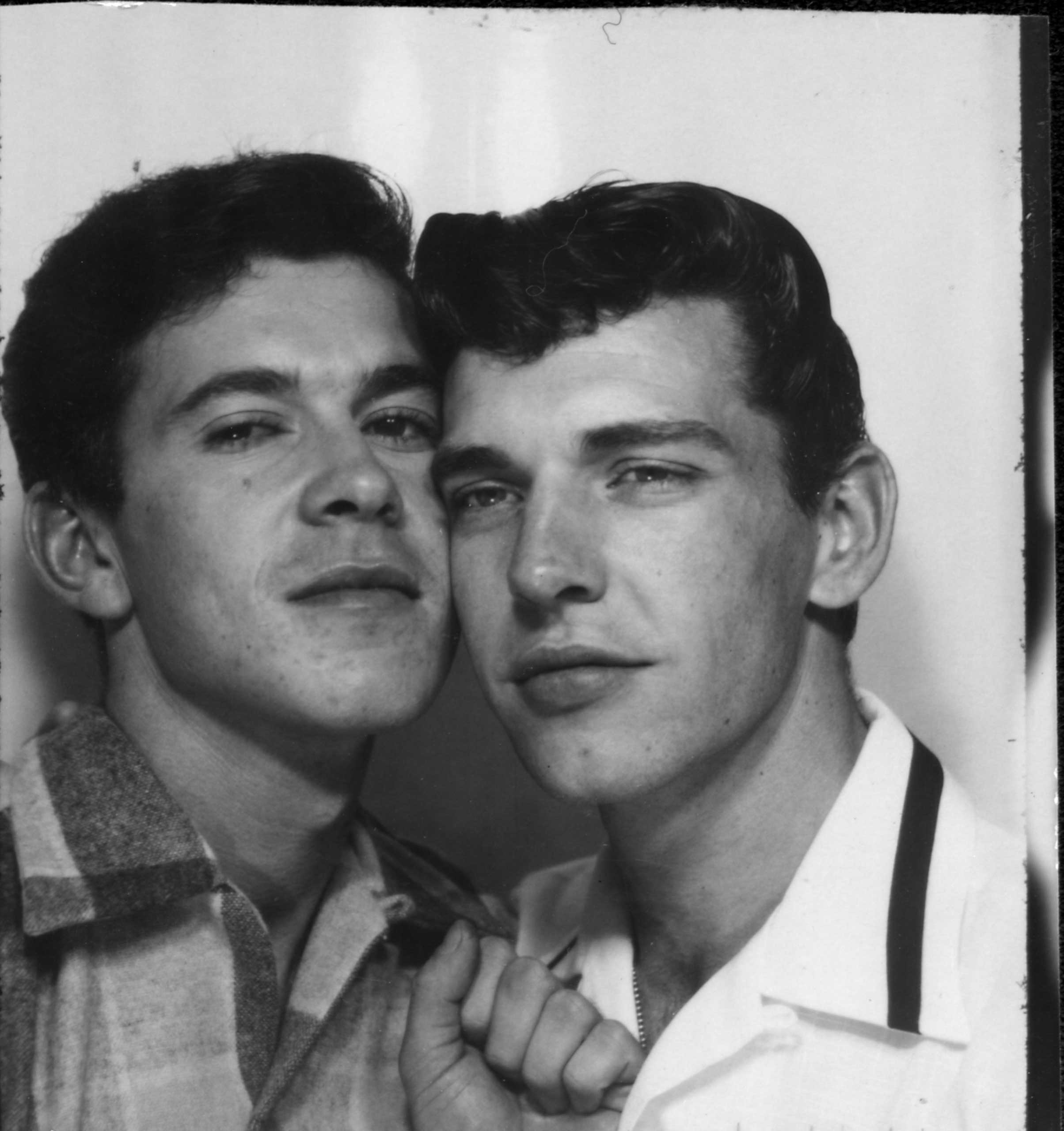 J. J. Belanger cheek-to-cheek with a man in a photo booth.  PGE exhibition, Hastings Park.  Vancouver, Circa 1953.