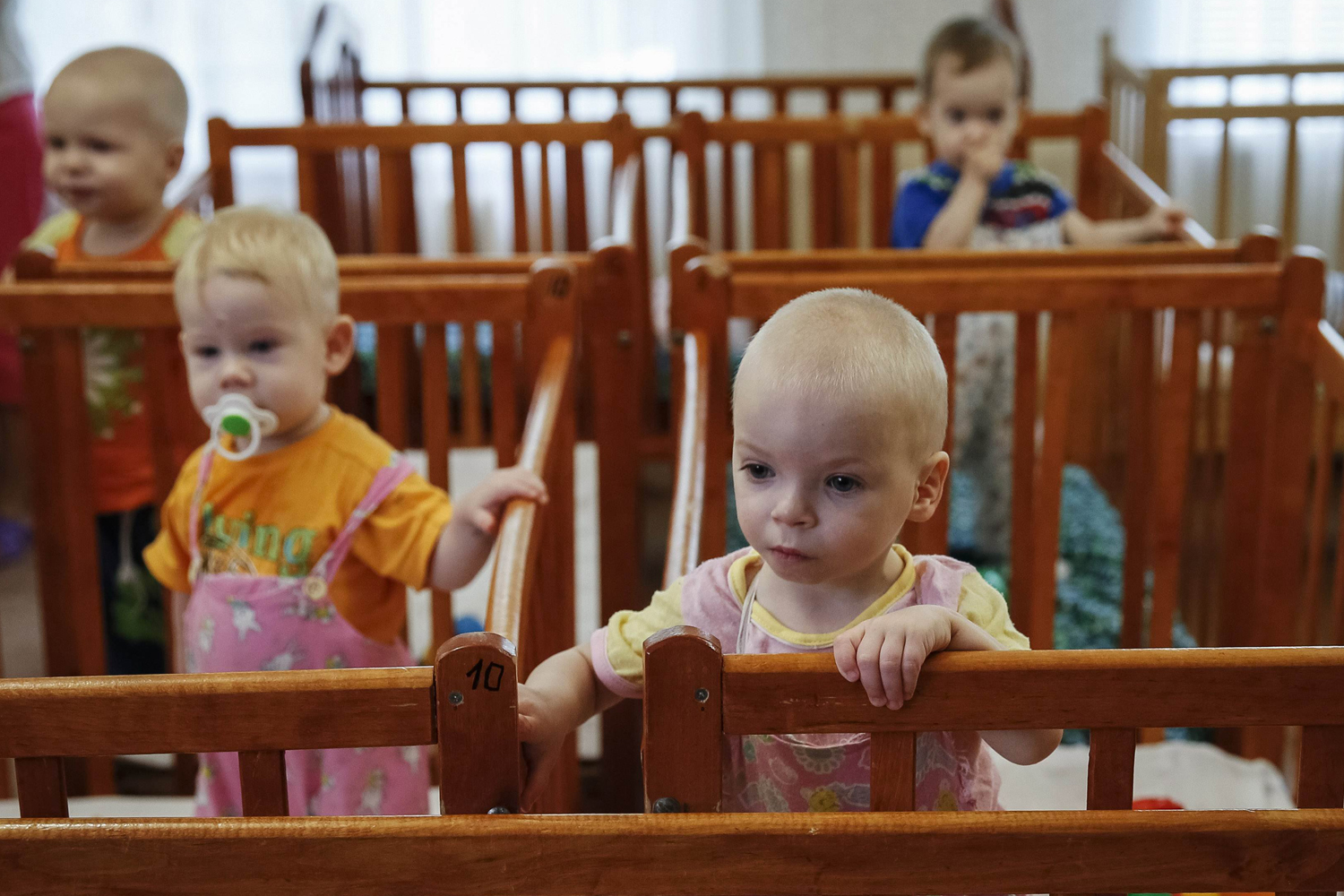 Children who were transferred from orphanages in Donetsk and Makeyevka stand in their cribs in an orphanage in Kramatorsk