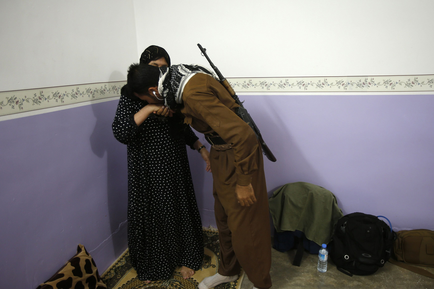 Mother says goodbye to her son, a volunteer in the Kurdish peshmerga forces, as he prepares to leave home for the front line near Tuz Khurmatu