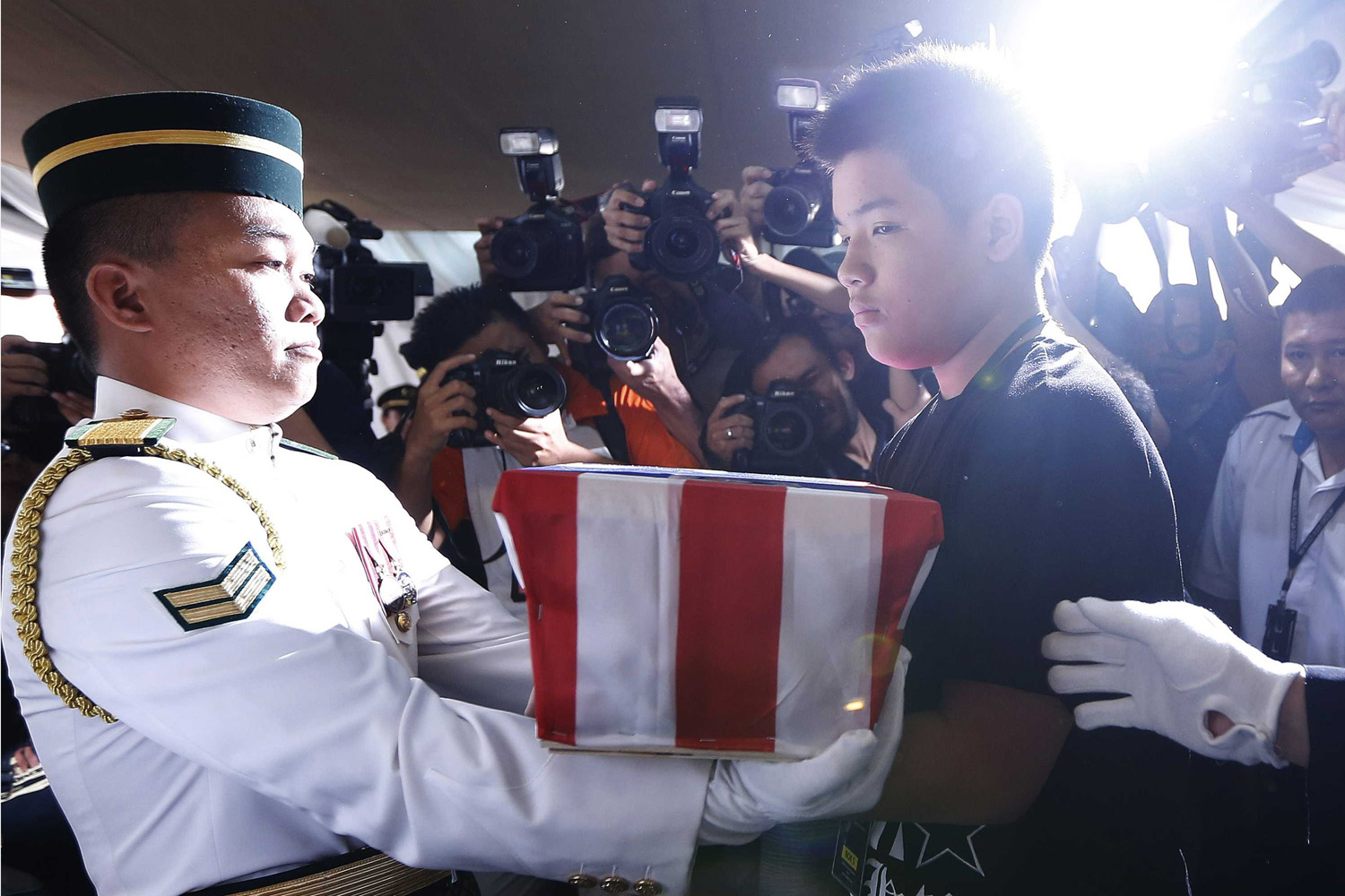 Melvic Choo, 13, takes the ashes of his father MH17 co-pilot Eugene Choo at his wake in Seremban