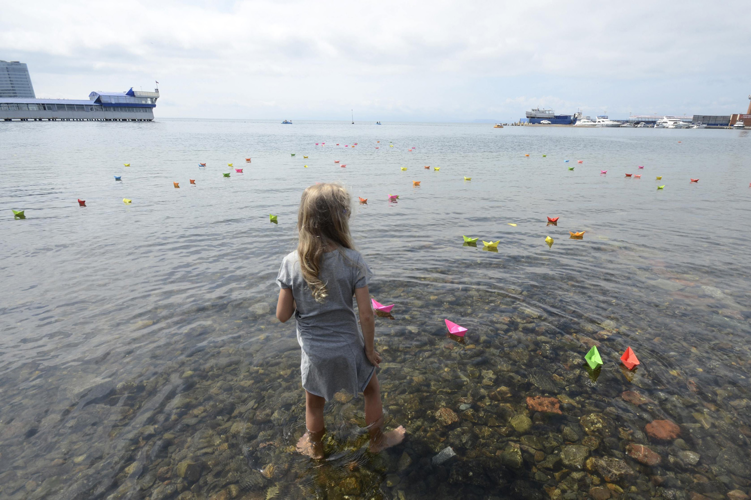 Girl looks at paper boats launched during celebrations for the 69th anniversary of the end of World War Two in the far eastern city of Vladivostok