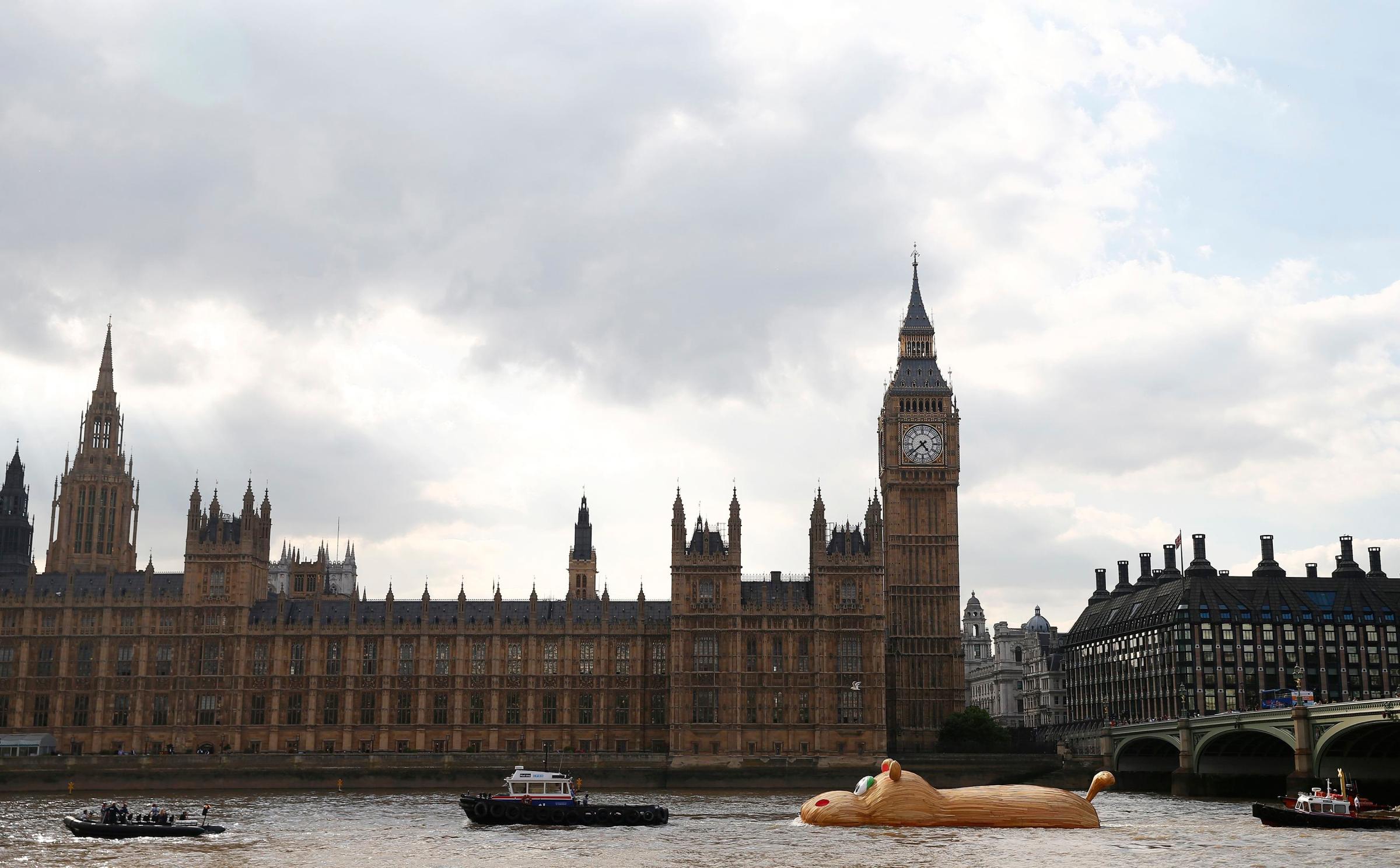 A sculpture of a giant hippopotamus, "HippopoThames", built by artist Florentjin Hofman is towed up the Thames past the Houses of Parliament in central London on Sept. 2, 2014.