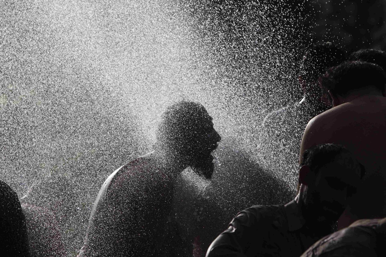 An anti-government protester takes a morning bath with others at public pump during the Revolution March in Islamabad