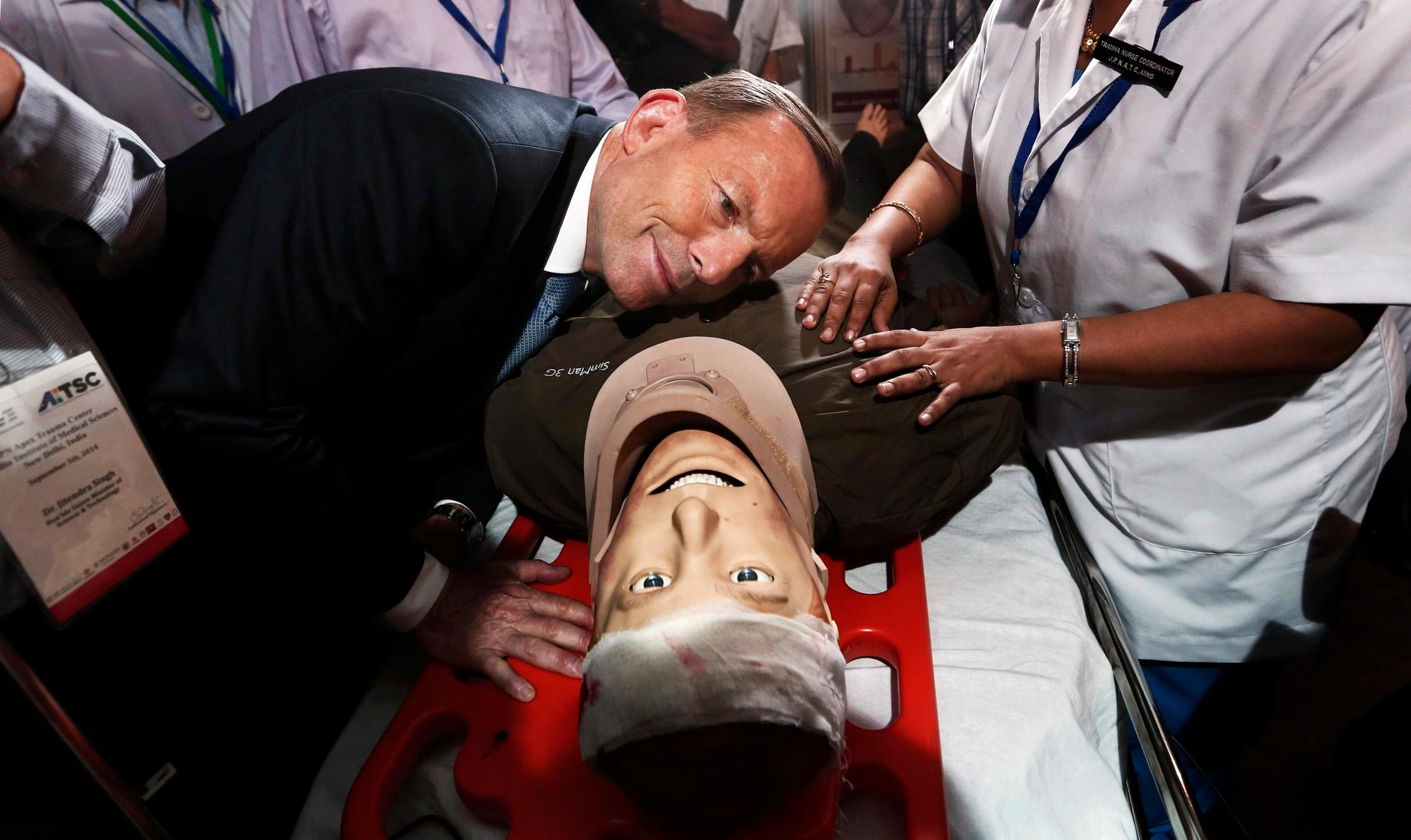 Australian Prime Minister Tony Abbott takes part in a presentation with a patient simulator during his visit to the trauma centre of the All India Institutes of Medical Sciences in New Delhi on Sept. 5, 2014.