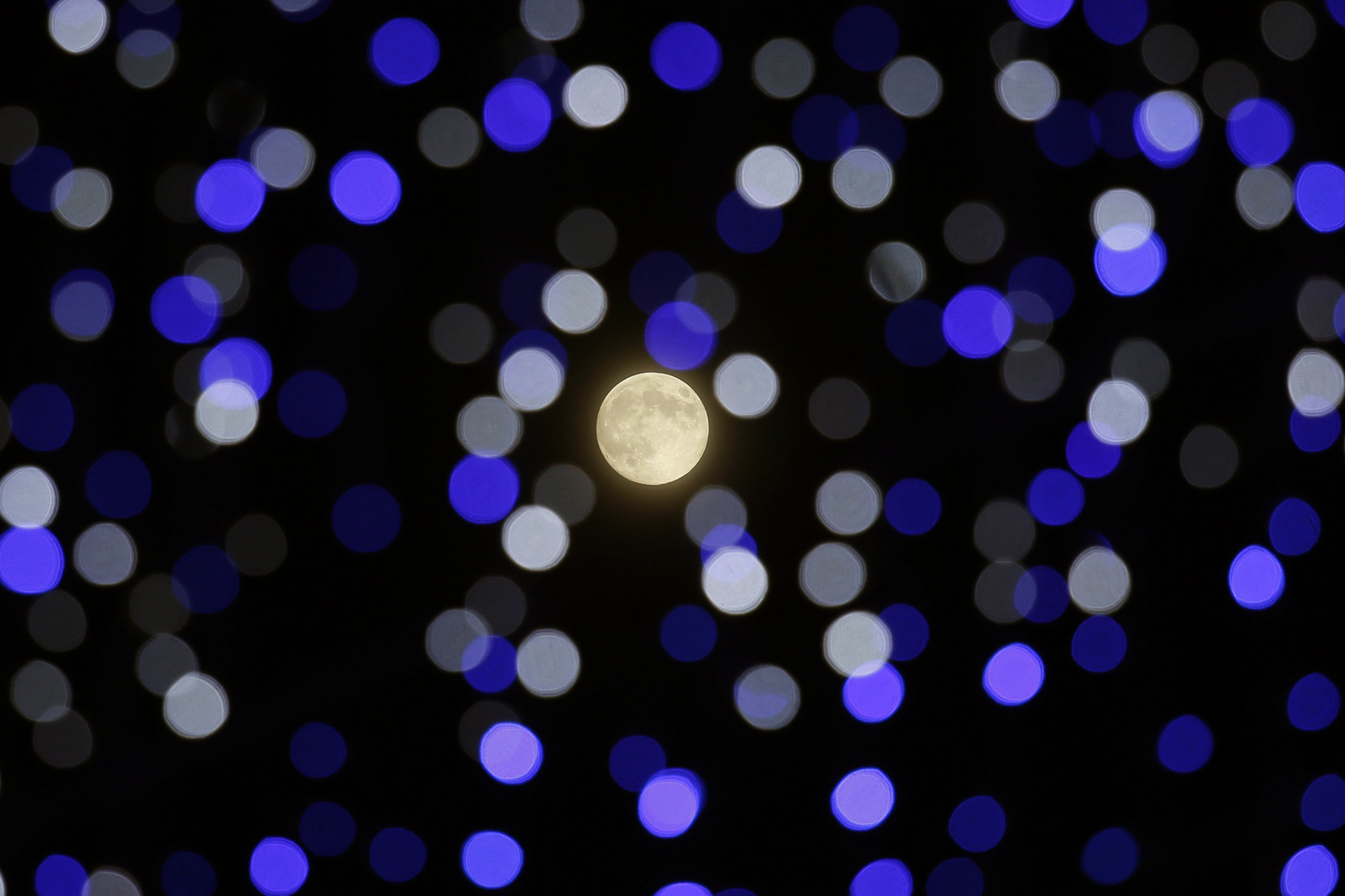 The moon shines in between lighting installation during Mid-Autumn or Lantern Festival at Hong Kong's Victoria Park