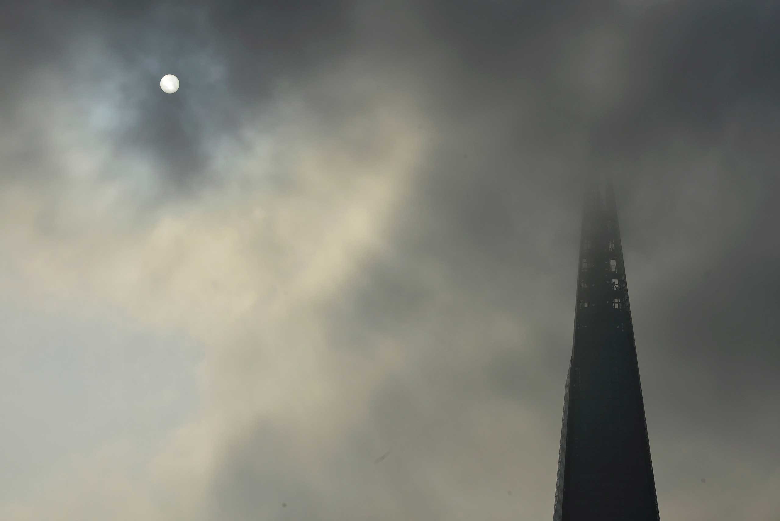 Sept. 19, 2014. The sun begins to shine through morning fog next to the Shard in central London.