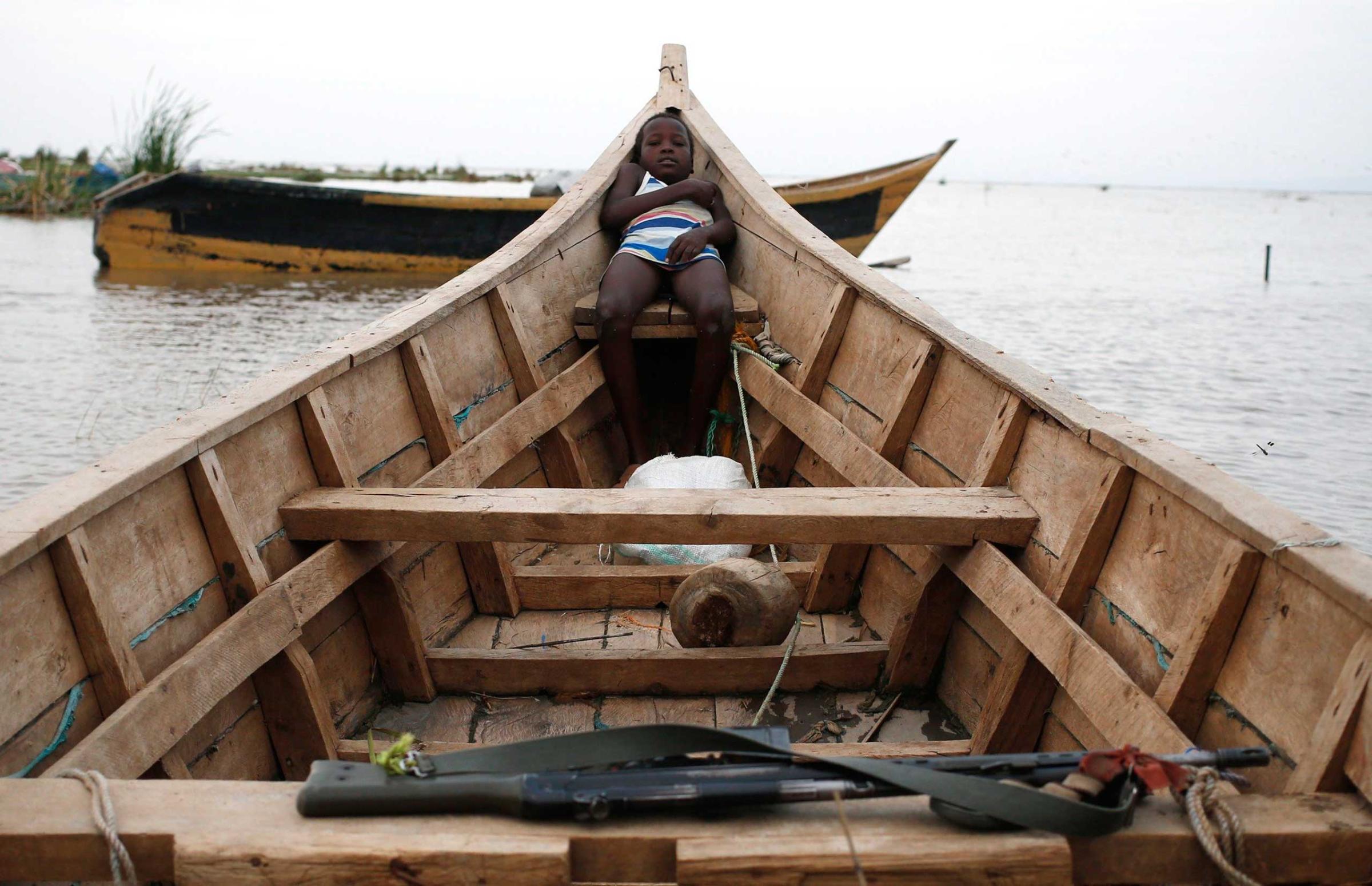 A Dassanach boy rests on a boat on the shore of a fishing camp near the Omo Delta in the north of Lake Turkana close to the town of Ileret and near the Kenyan-Ethiopian border in northern Kenya