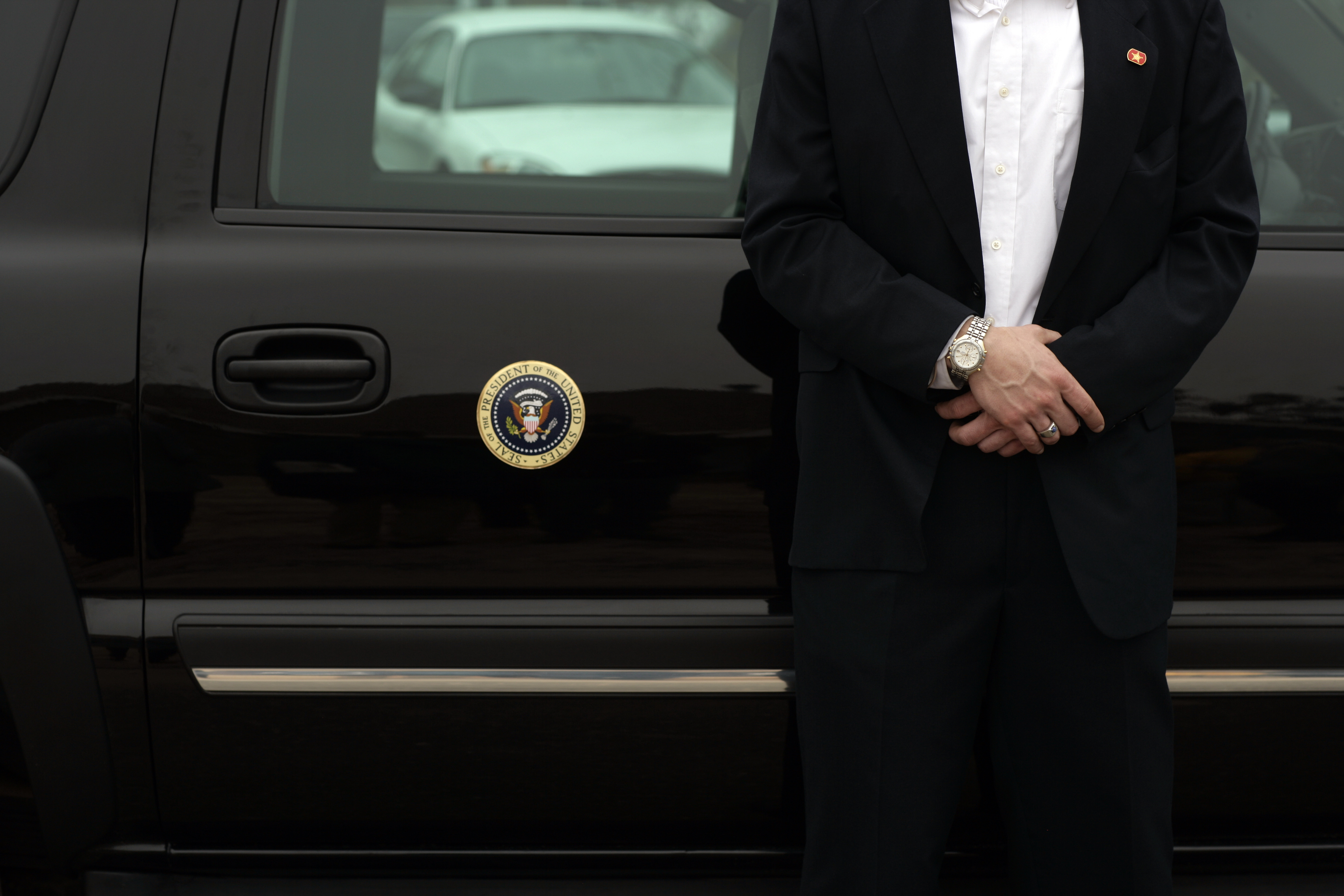 A Secret Service agent stands guard in front of President George W Bush's vehicle, while he tours rebuilding efforts in a neighborhood affected by Hurricane Katrina, in Long Beach, Miss. on March 1, 2007.
