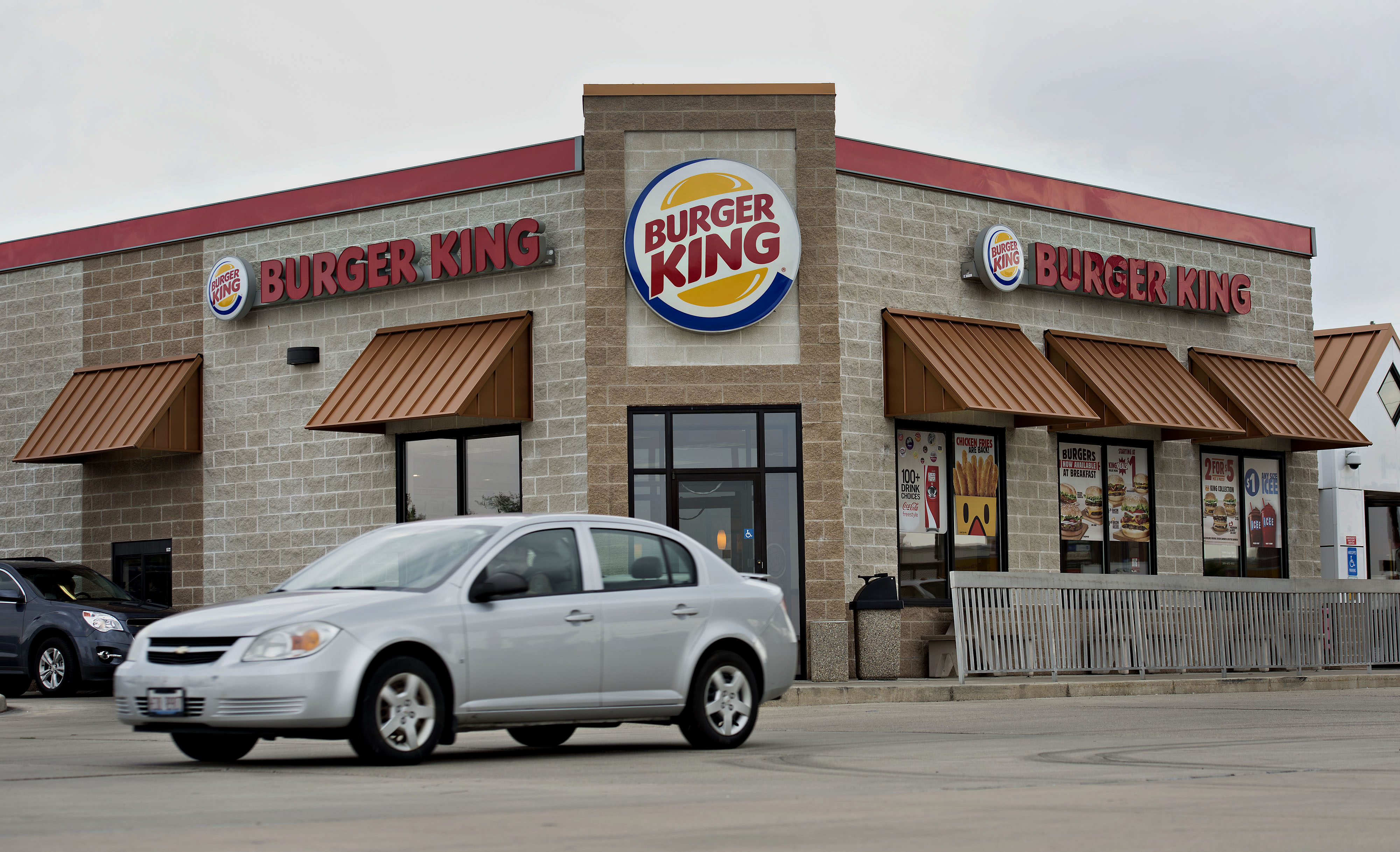A vehicle drives past a Burger King Worldwide Inc. restaurant in Peoria, Illinois, U.S., on Tuesday, Aug. 26, 2014. Burger King Worldwide Inc. agreed to acquire Tim Hortons Inc. for about C$12.5 billion ($11.4 billion) in a deal that creates the third-largest fast-food company and moves its headquarters to Canada. (Bloomberg&mdash;Bloomberg/Getty Images)
