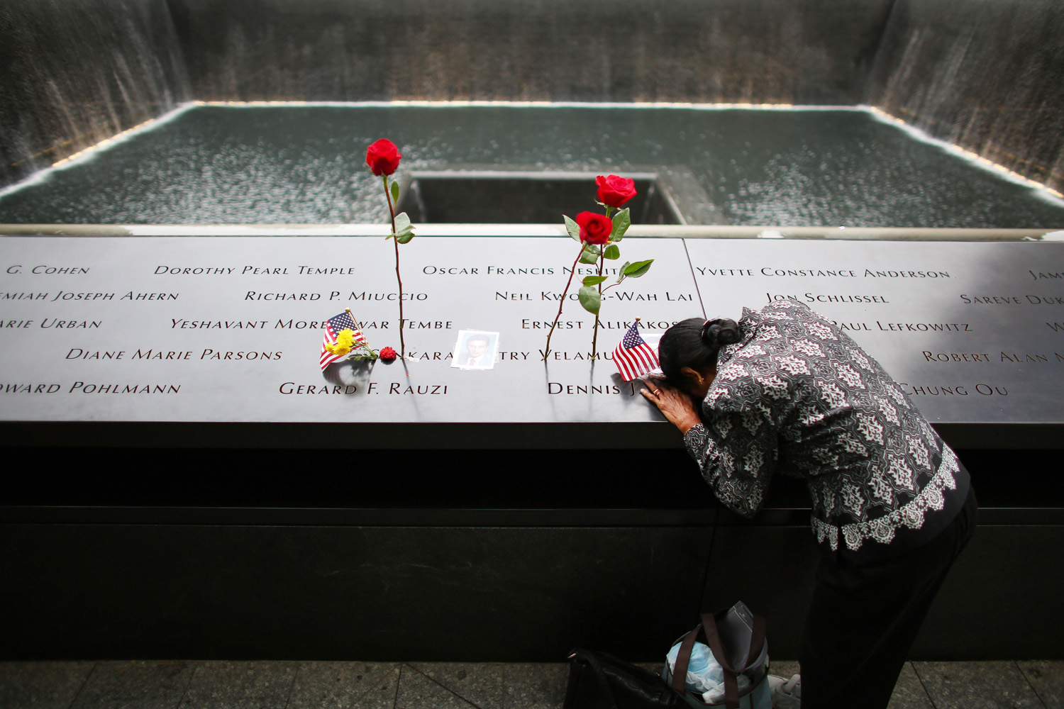 Sept. 11, 2014. A woman grieves at her husband's memorial at South Tower Reflecting Pool before the memorial observances held at the site of the World Trade Center before memorial observances are held at the site of the World Trade Center in New York City. This year marks the 13th anniversary of the September 11th terrorist attacks that killed nearly 3,000 people at the World Trade Center, Pentagon and on Flight 93.