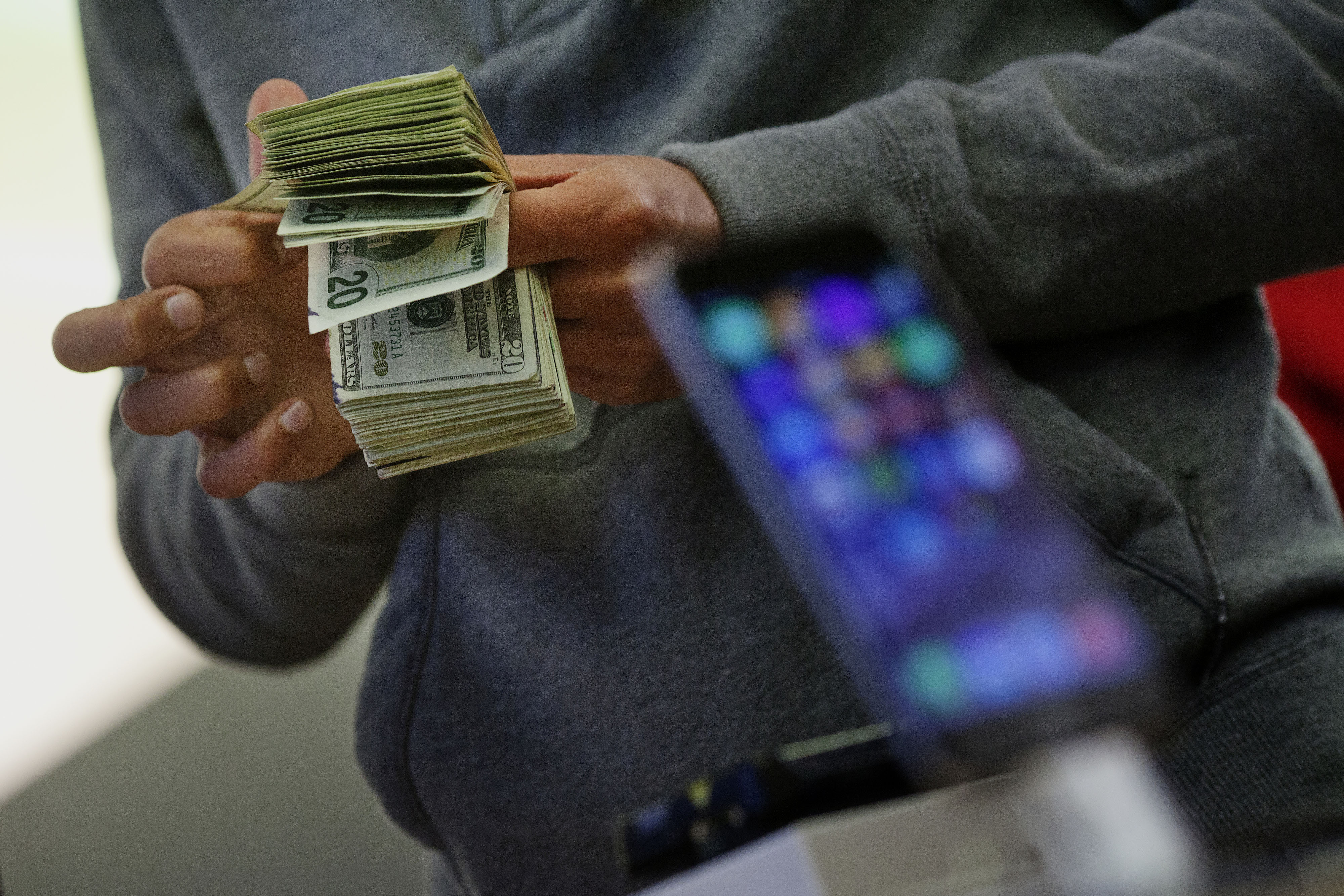 A customer counts cash to pay for two iPhone 6 smartphones during the sales launch at the Apple Inc. store in New York, U.S., on Friday, Sept. 19, 2014. (Bloomberg&mdash;Bloomberg via Getty Images)