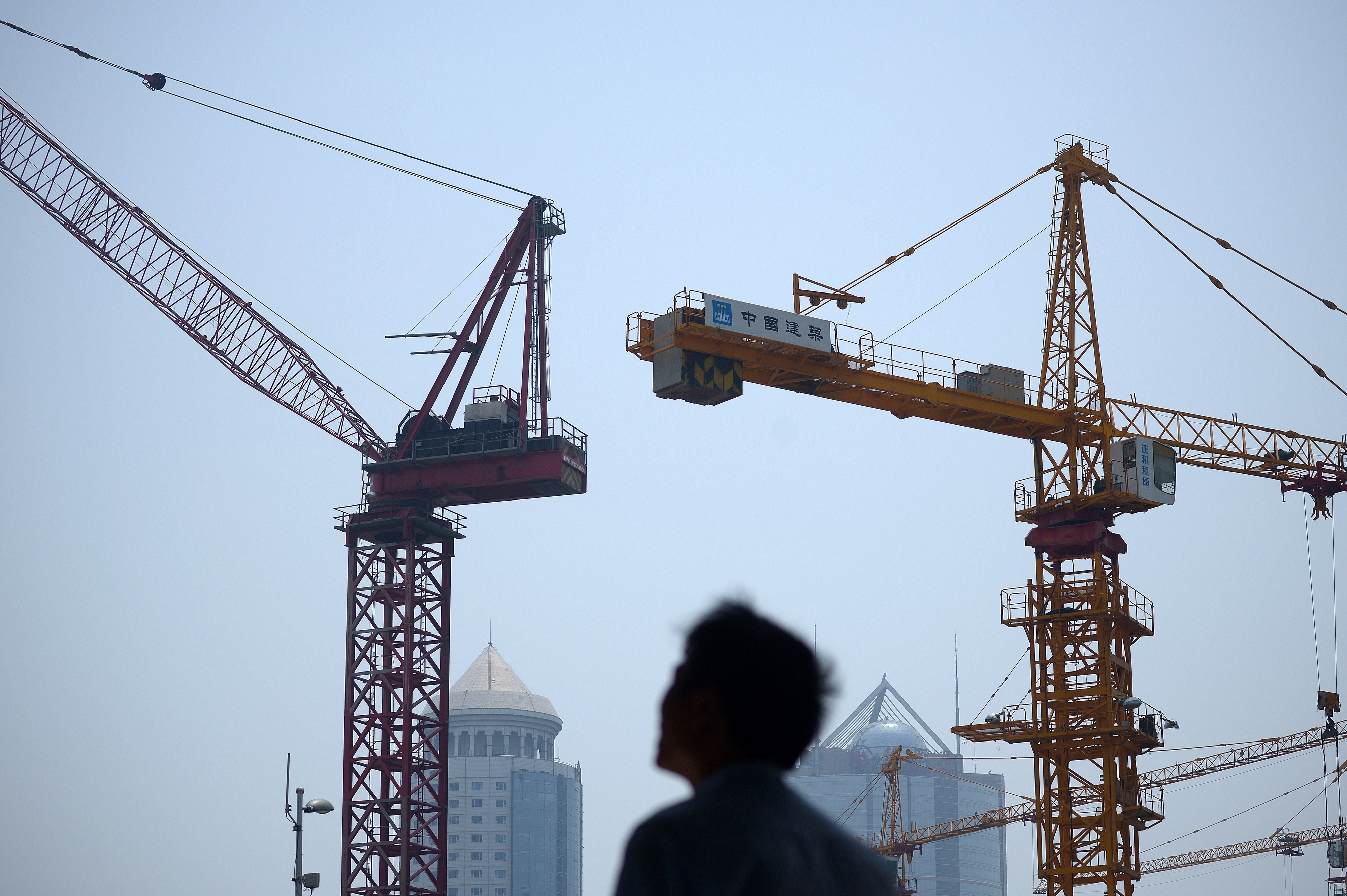 A man walks past a construction site in Beijing on May 30, 2014. After years of boom that have seen prices rocket, the prospect of a bust is looming over China's vast property sector. (WANG ZHAO—AFP/Getty Images)