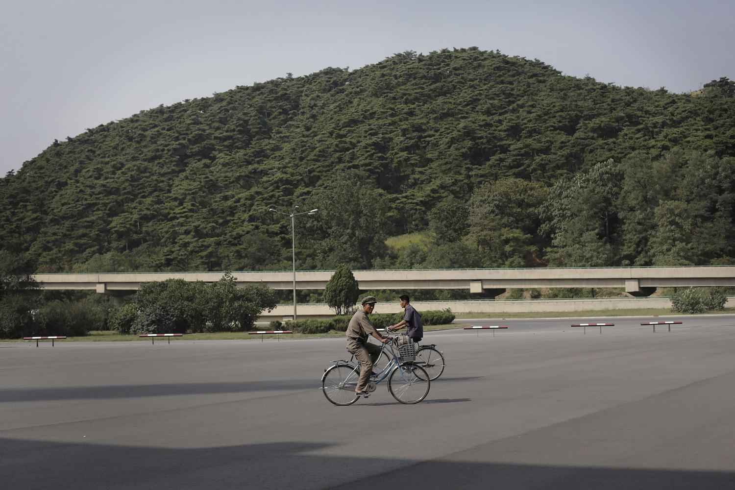 Men cycle as their form of commute in Pyongyang, Sept. 2, 2014.