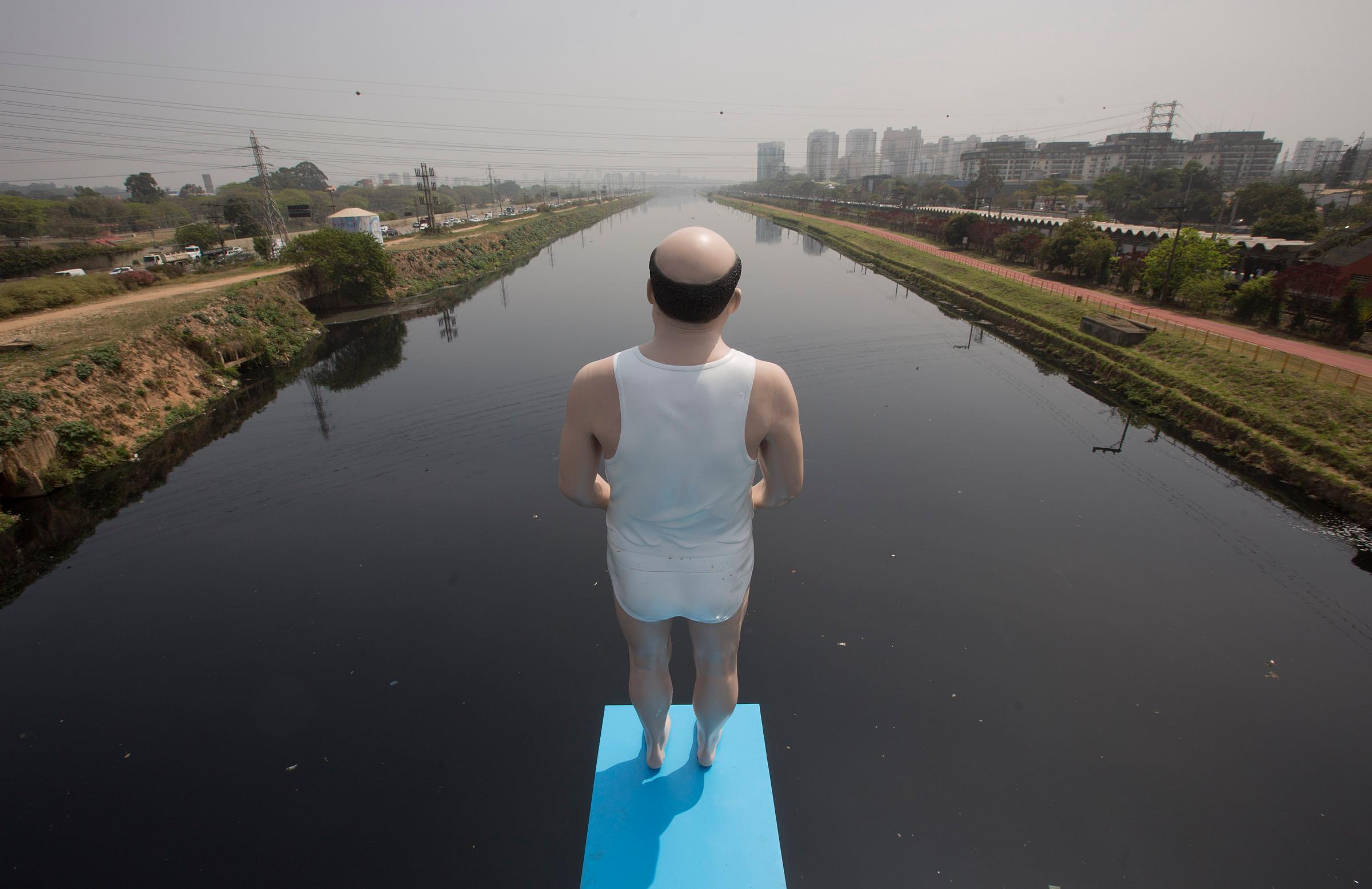 An art installation by Brazilian artist Eduardo Srur made with a life-size mannequin stands over the highly polluted Pinheiros River in Sao Paulo, Brazil on Sept. 18, 2014.