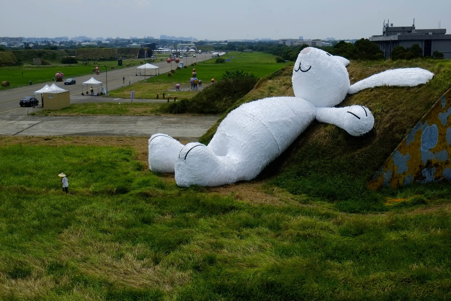 Sept. 2, 2014. Dutch artist Florentijn Hofman's latest creation, a 25 meters (82 feets) white rabbit, leans up against an old aircraft hangar as part of the Taoyuan Land Art Festival in Taoyuan, Taiwan.