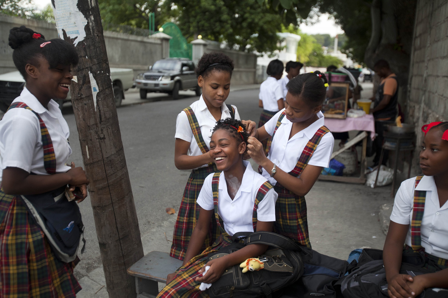 A high school student gets her hair adjusted by friends outside the Lycee Marie Jeanne public school for girls before the start of their first day back to school in Port-au-Prince, Haiti on Sept. 8, 2014.