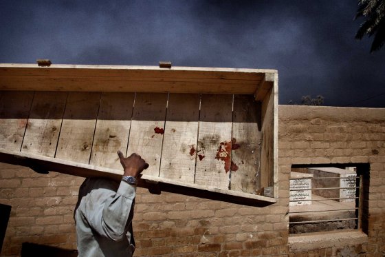 Yuri Kozyrev, March 31, 2003A Sheikh Maaruf cemetery worker carries a reusable casket to the storage house after the funeral of Nidal Ali Jasem, a lonely deaf and dumb woman killed in a rocket blast in the south of Baghdad. I was in Baghdad with a hundred journalists during 