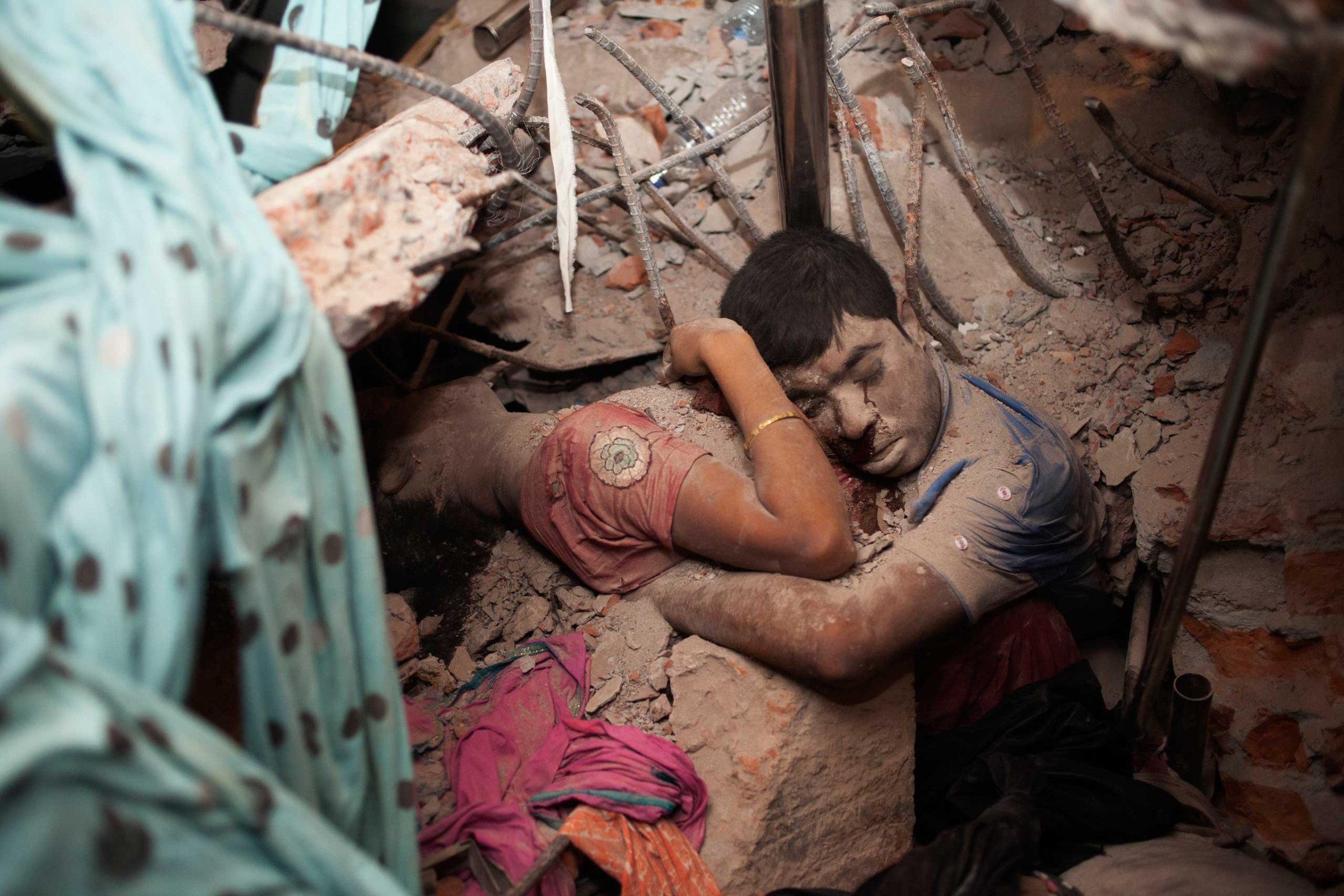 April 25, 2013. Two victims amid the rubble of a garment factory building collapse in Savar, near Dhaka, Bangladesh.