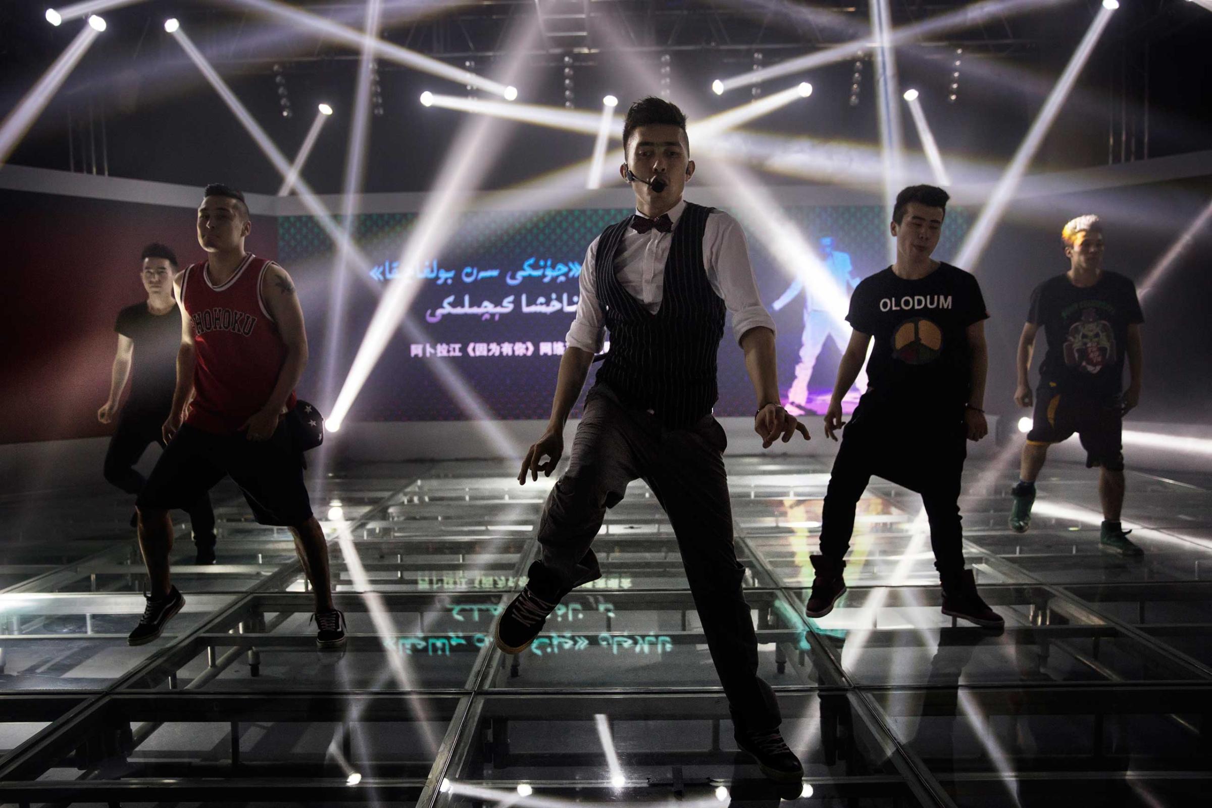Ablajan performs on stage with his dancers at rehearsals for a planned live webcast concert scheduled for that afternoon in Urumqi, China on July 31, 2014.
