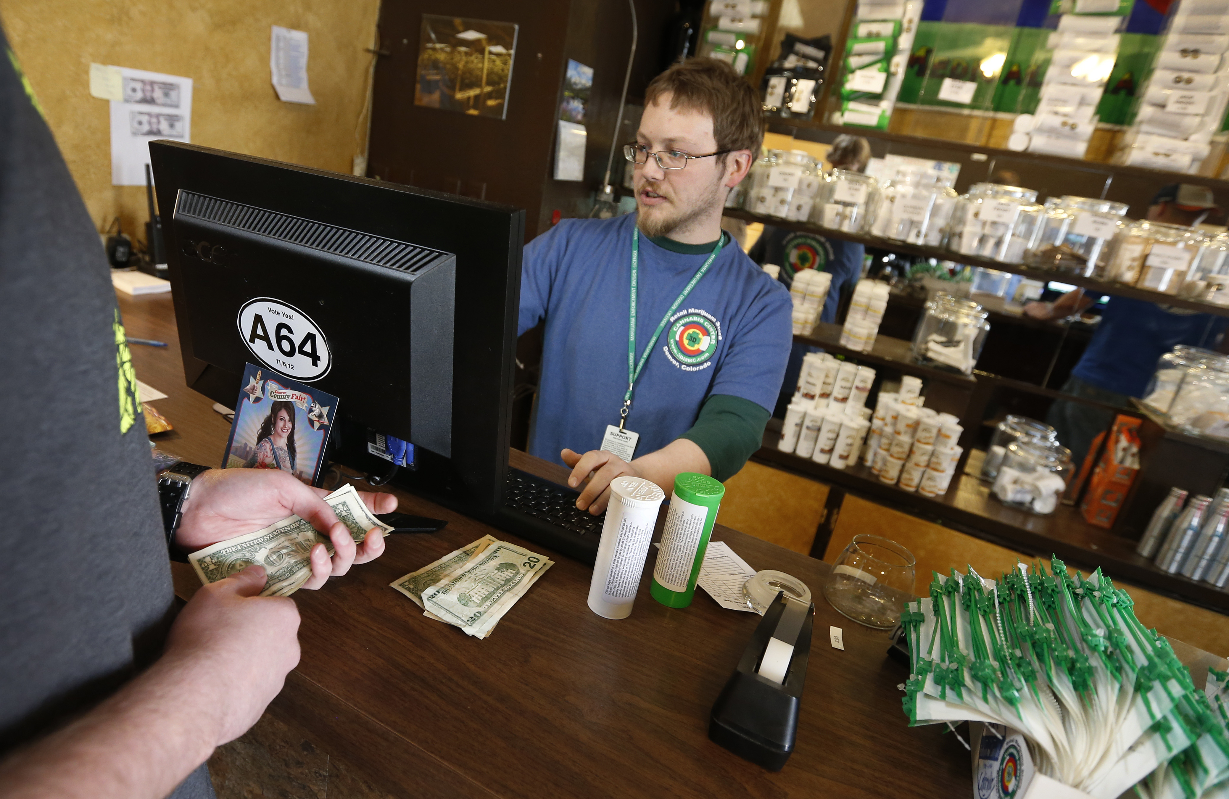 A customer pays cash for retail marijuana at 3D Cannabis Center, in Denver, Thursday, May 8, 2014. (Brennan Linsley—ASSOCIATED PRESS)