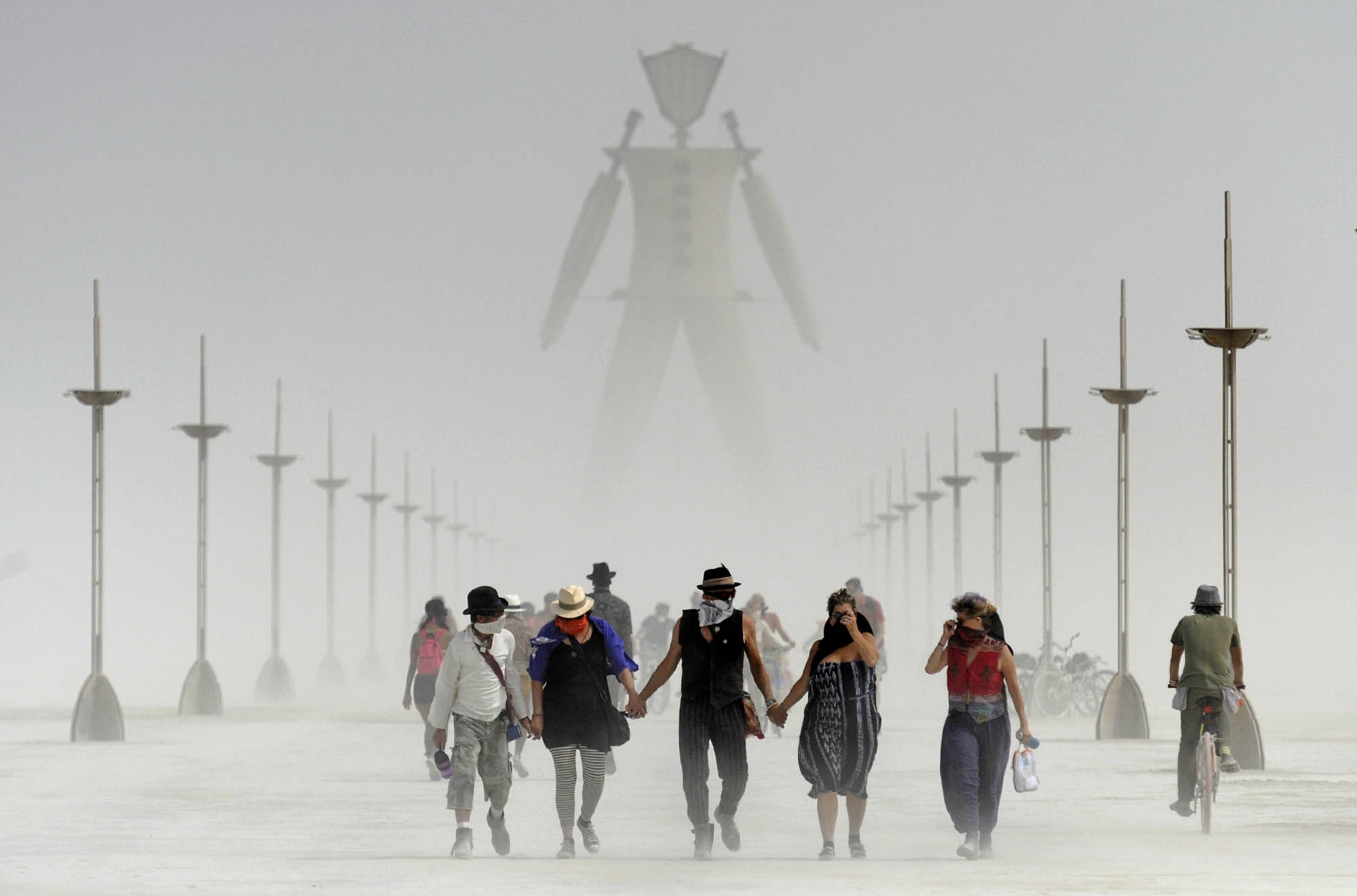 Burning Man participants walk through dust at the annual Burning Man event on the Black Rock Desert of Gerlach, Nev., on Friday, Aug. 29, 2014. Organizers call Burning Man the largest outdoor arts festival in North America, with its drum circles, decorated art cars, guerrilla theatrics and colorful theme camps. (Andy Barron—AP)