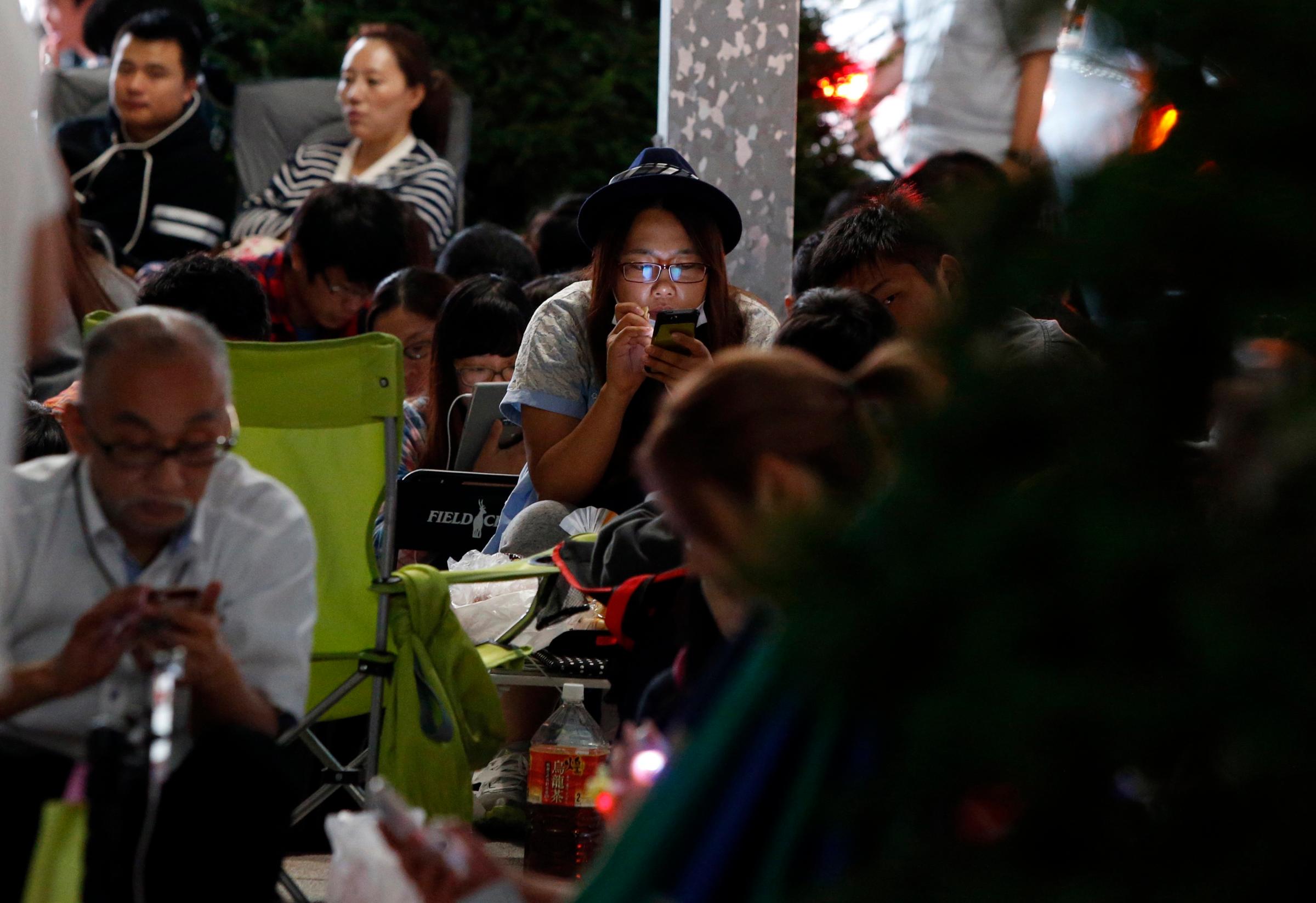 People wait for the release of Apple's new iPhone 6 and 6 Plus in front of the Apple Store in Tokyo on Sept. 18, 2014.
