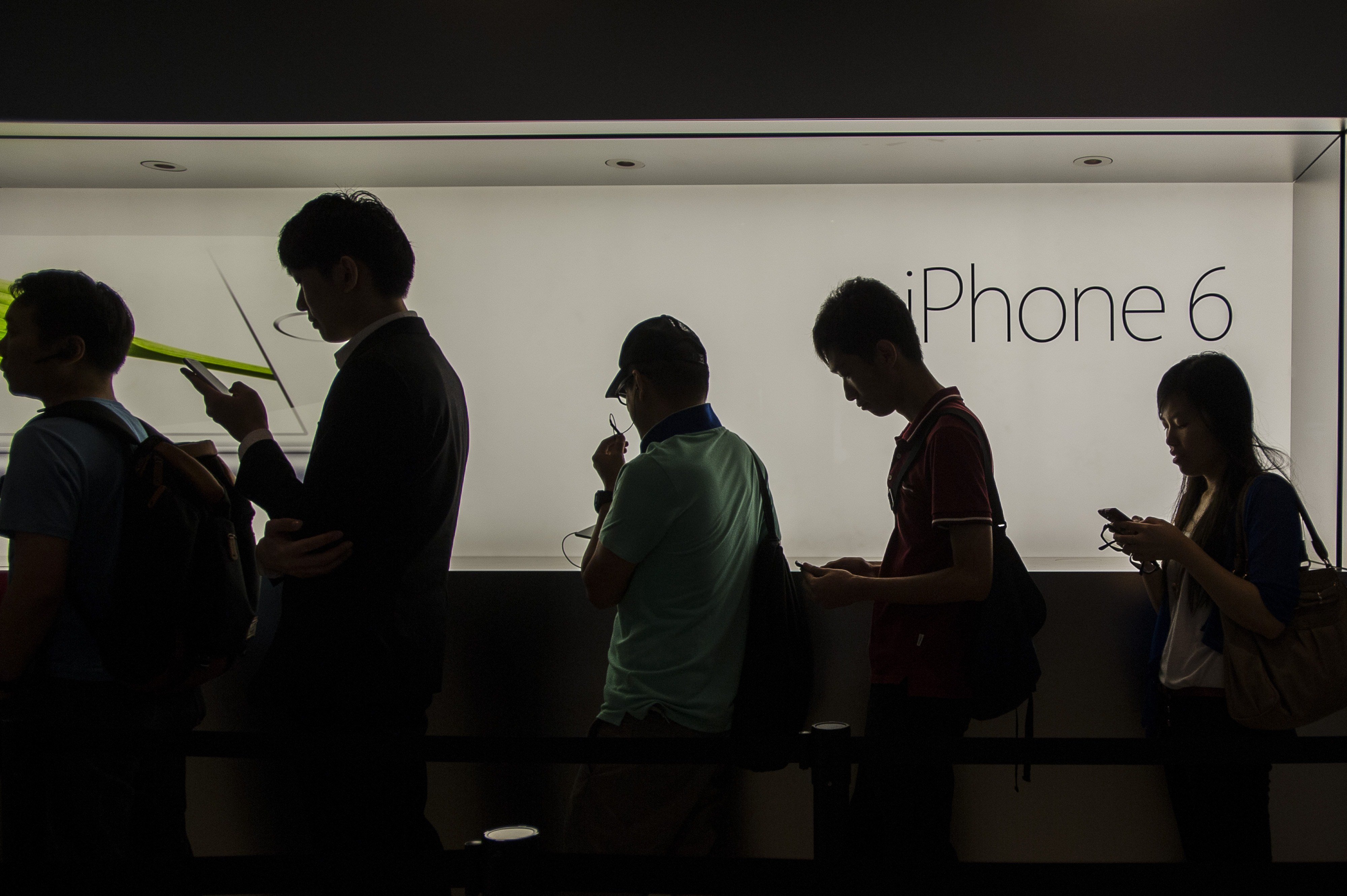 Customers queue outside an Apple store in Hong Kong on Sept. 19, 2014.