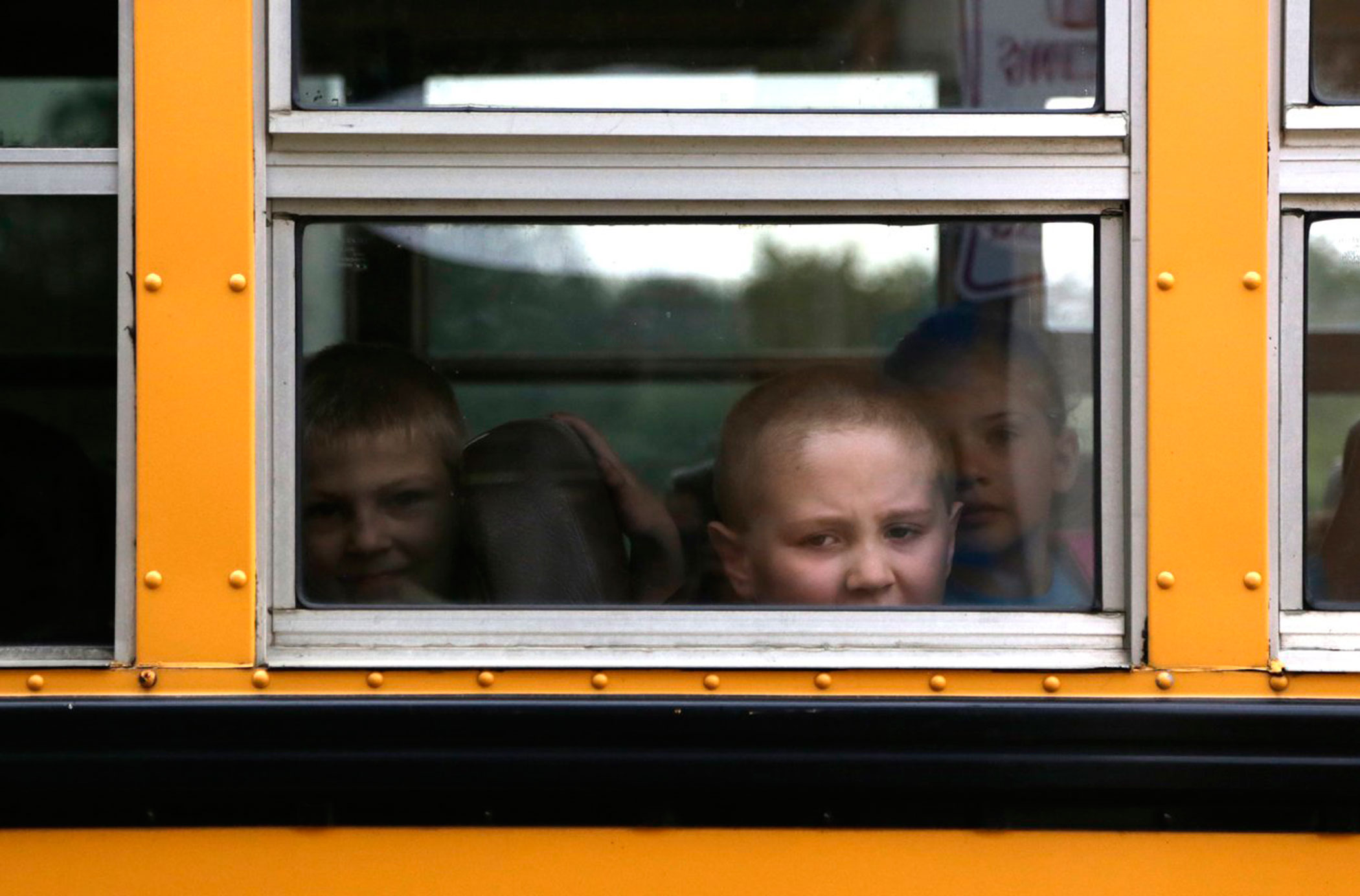 A student looks out of a bus toward Bertha Robinson Elementary school during the first day back from summer break on Sept. 2, 2014 in Leoni Township, MI.