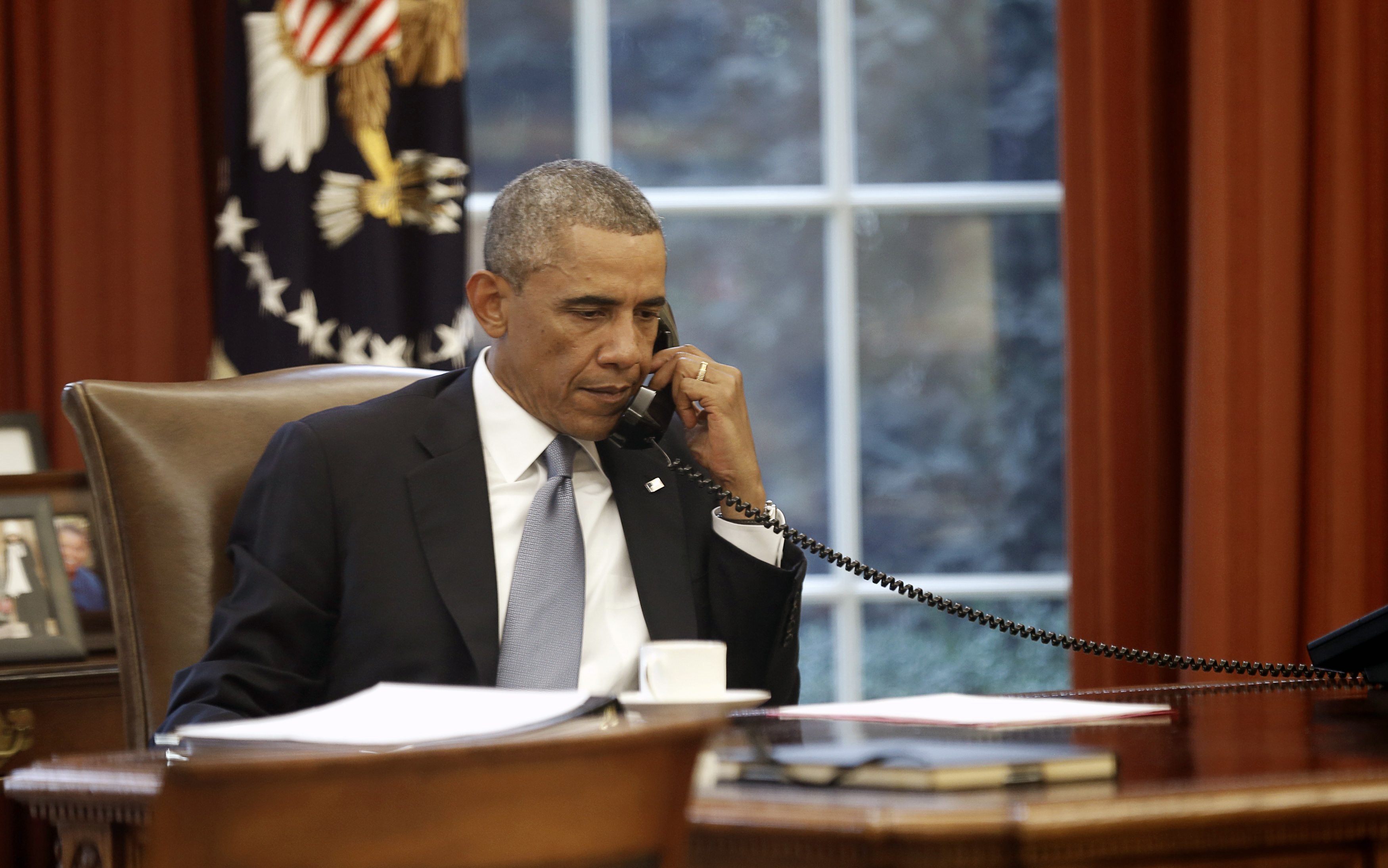 U.S. President Barack Obama speaks on the phone with Saudi King Abdullah from the  Oval Office of the White House in Washington