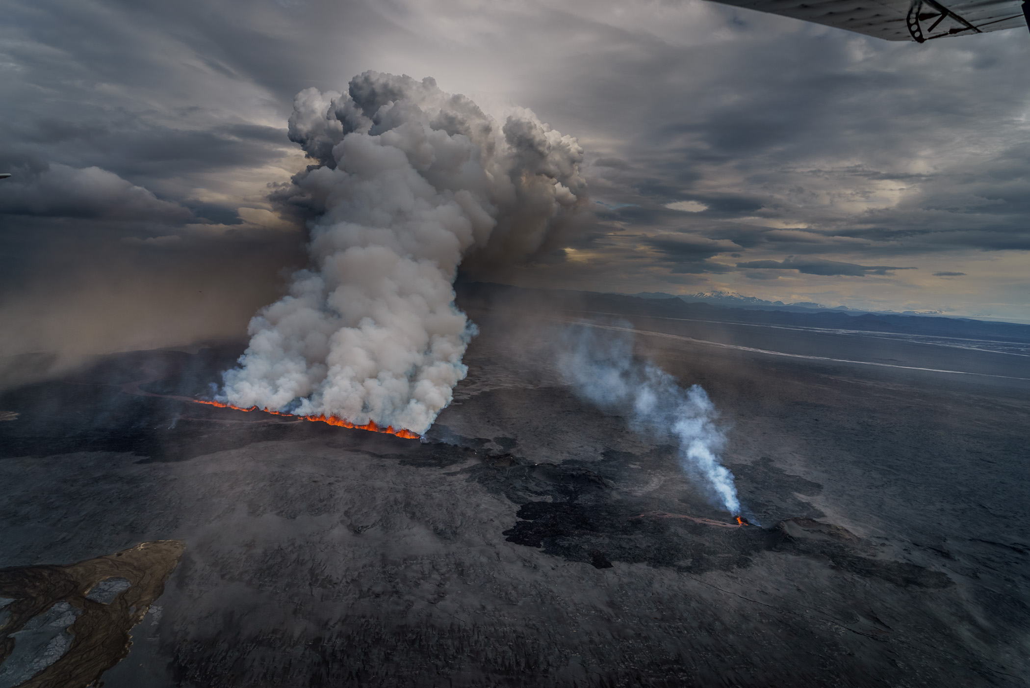 Heavy activity in the northern half of the fissure sent a white plumb some 15,000 feet into the sky and pushed lava across the cold sand below. Bardarbunga, Sept. 1.