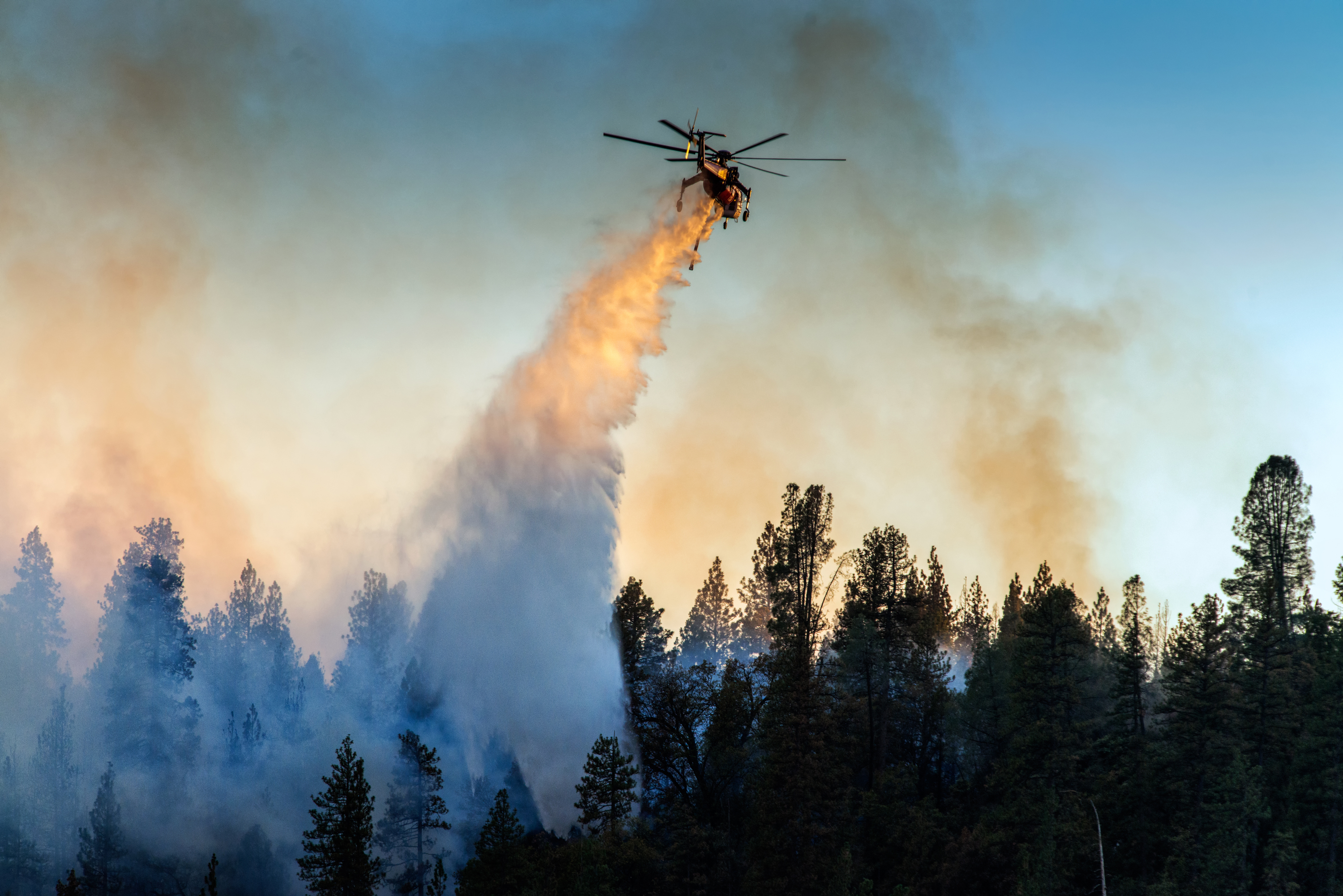 A firefighting helicopter makies a water drop over a wildfire at Bass Lake, Calif. on Sept. 14, 2014.