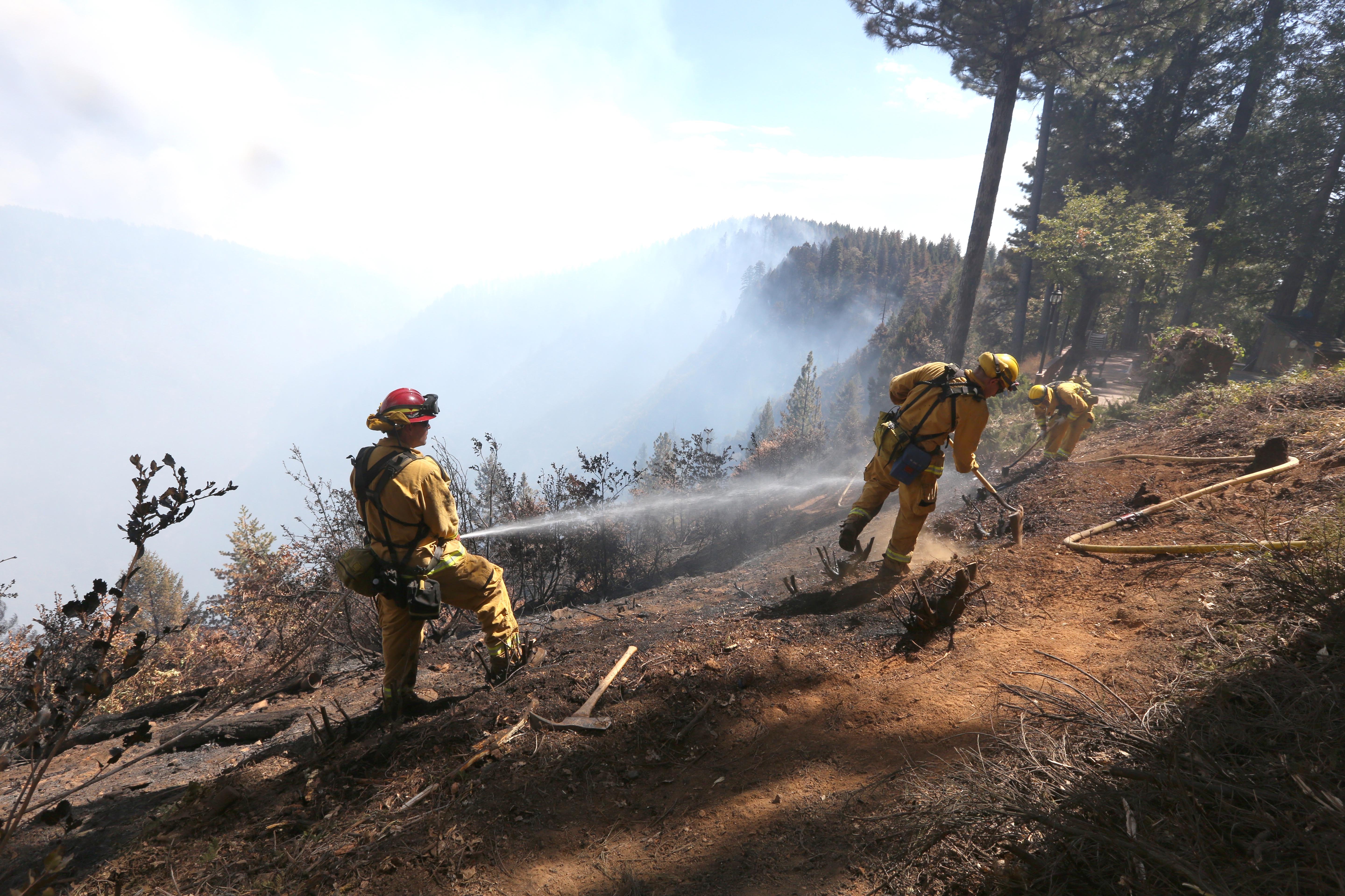 Firefighters hose down hot spots of the King Fire near Pollack Pines, Calif., on Sept. 15, 2014.