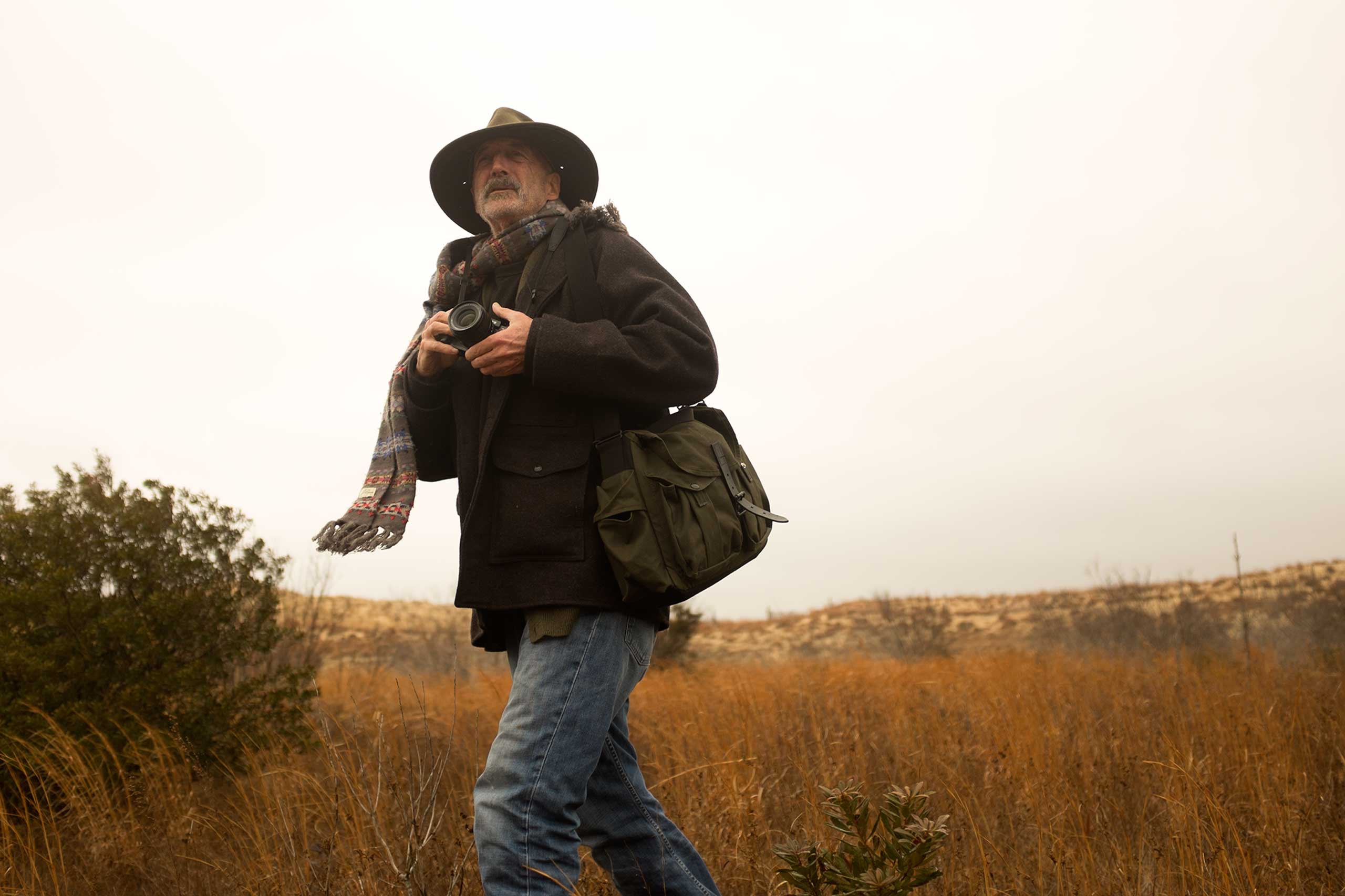 Harvey shooting on location with the bag he designed for Filson