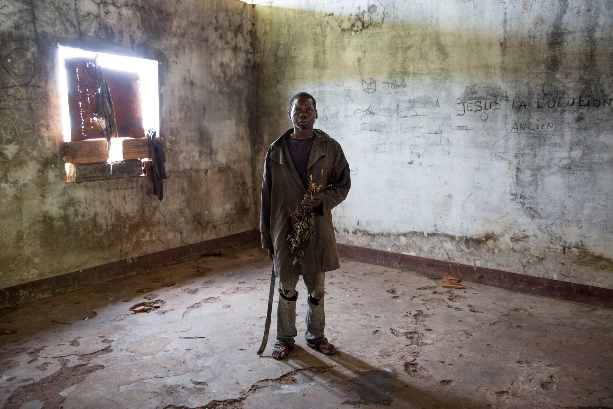 Feb. 2, 2014: A man poses in former Emperor Jean-Bédel Bokassa's compound near the village of Pissa. He is one of the many Christians there, originally recruited by Séléka to become soldiers, but later abandoned by their leader. No food is available so they hunt rats to eat, fearing to leave as they could be considered Séléka collaborators.