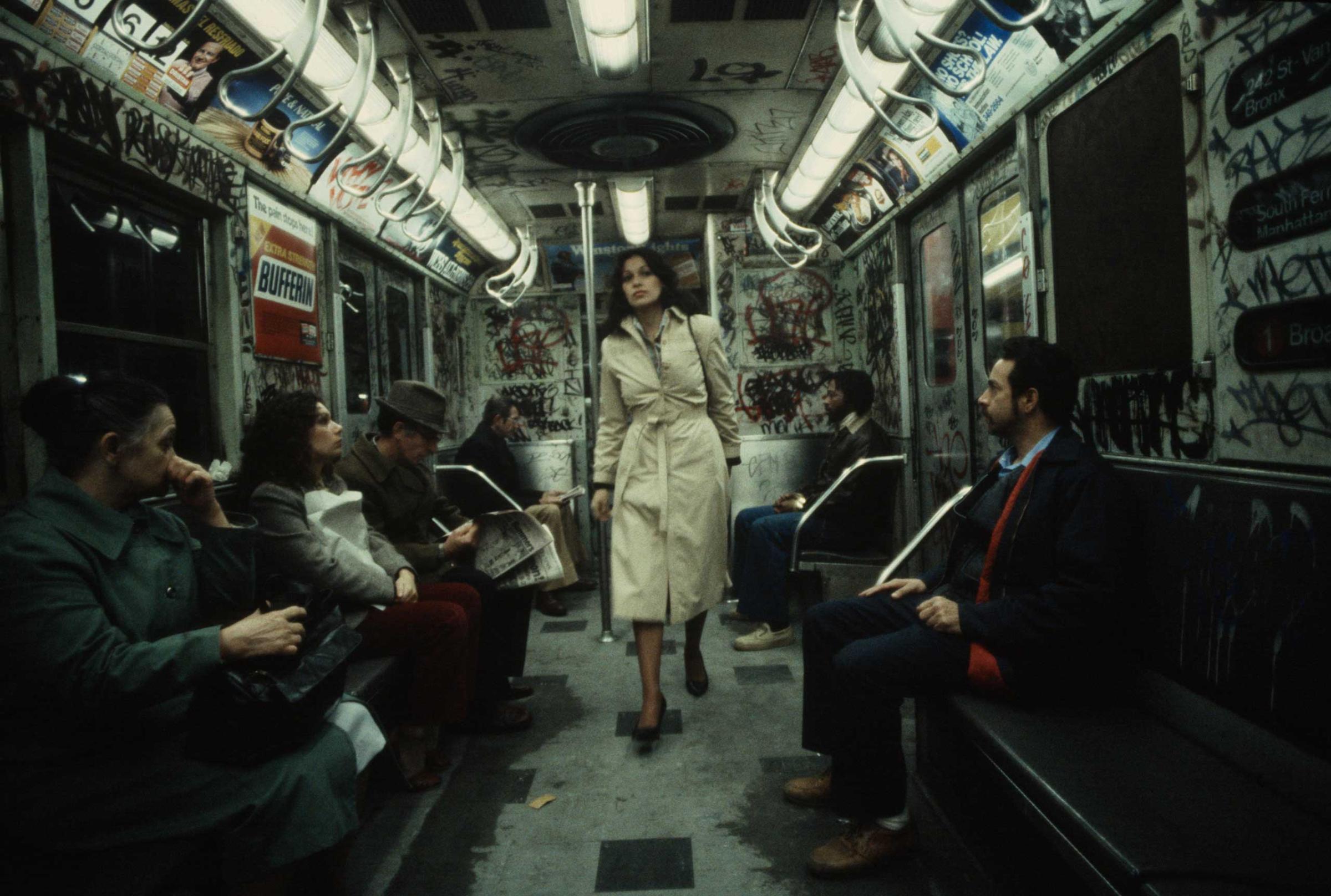 The following previously unpublished photos were taken by Christopher Morris in 1981: A woman walks through a heavily graffitied subway car, 1981.