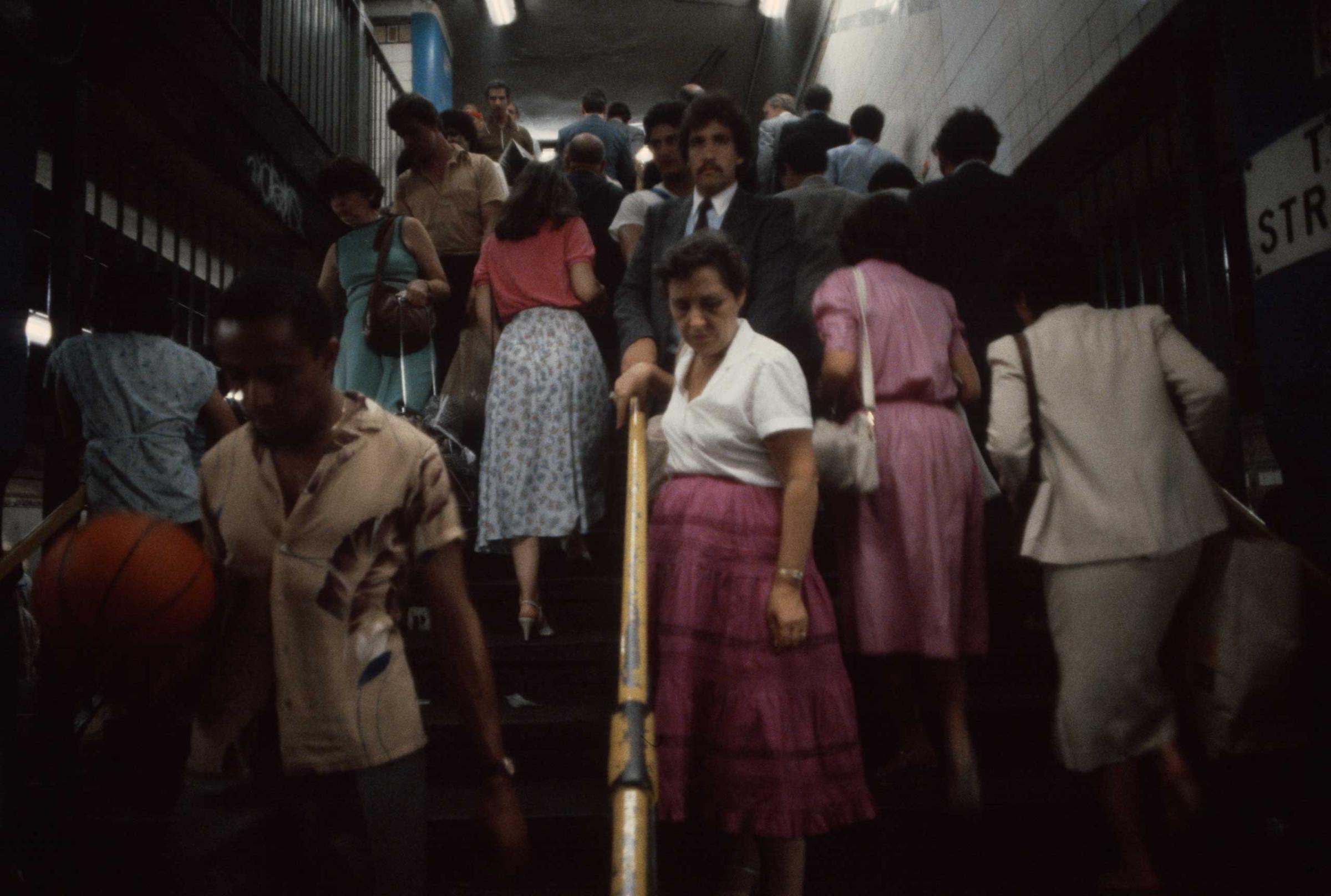 Commuters ascend and descend stairwells during rush hour, 1981.