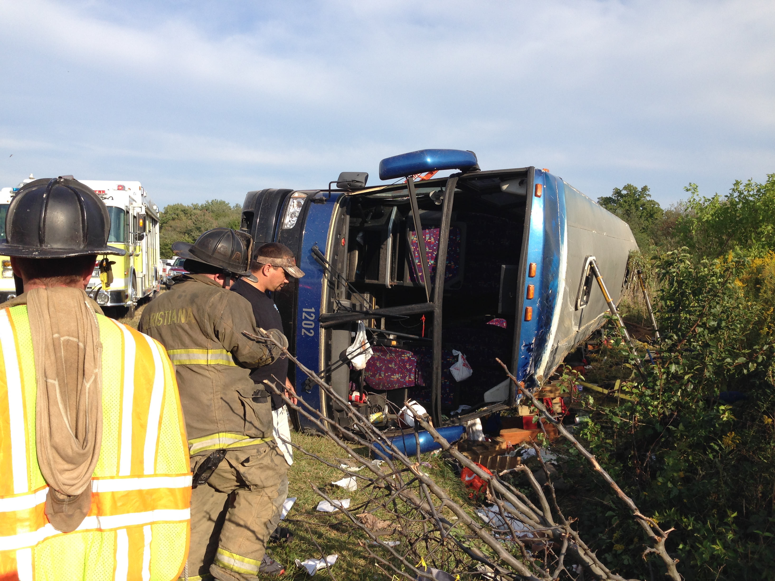 Passengers from a tour bus are treated for injuries near the overturned bus at the Tybouts Corner on ramp from southbound Del. 1 to Red Lion Road in Bear, Del. on Sept. 21, 2014. (John J. Jankowski—The Wilmington News-Journal/AP)