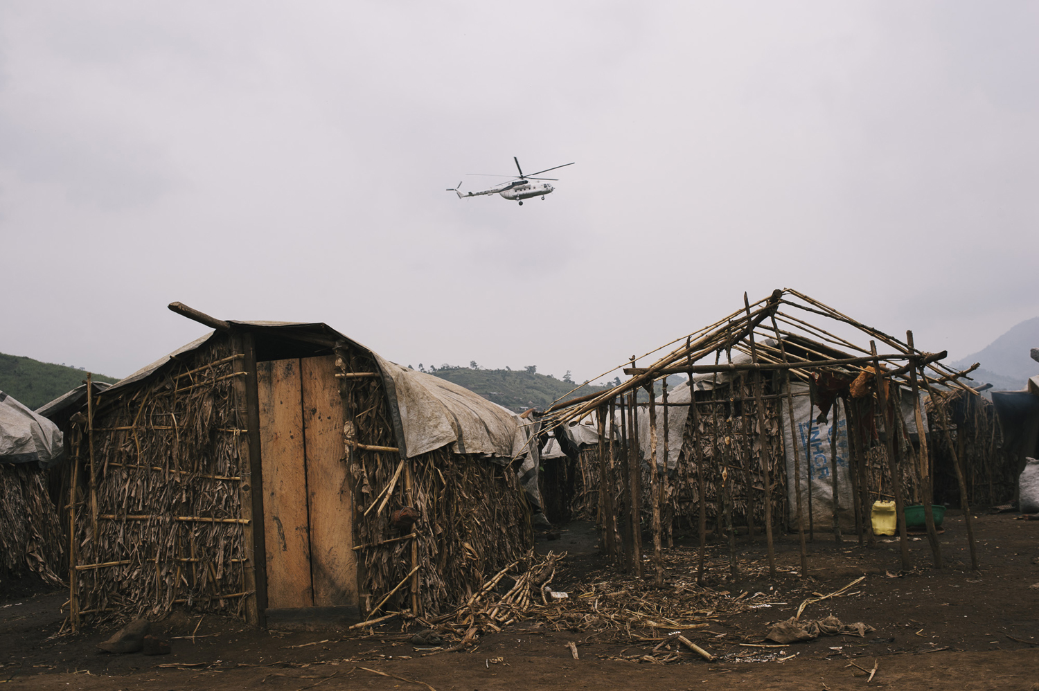 A United Nations helicopter flies over make-shift house in a camp for internally displaced persons in the town of Nyabiondo, July 21, 2014.