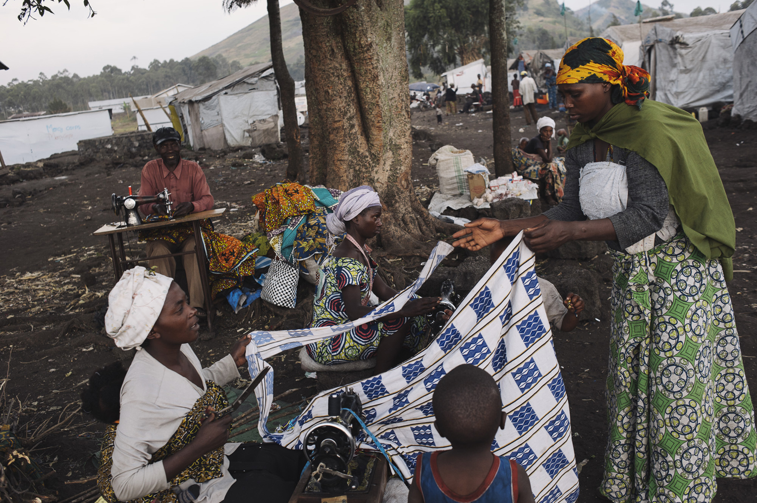 Displaced Congolese work as seamstresses in the small market of the Bulengo displacement site. When fleeing conflict, people take only what they can carry, but sewing machines can provide a vital source of income when arriving in camps such as Bulengo, July 14, 2014.