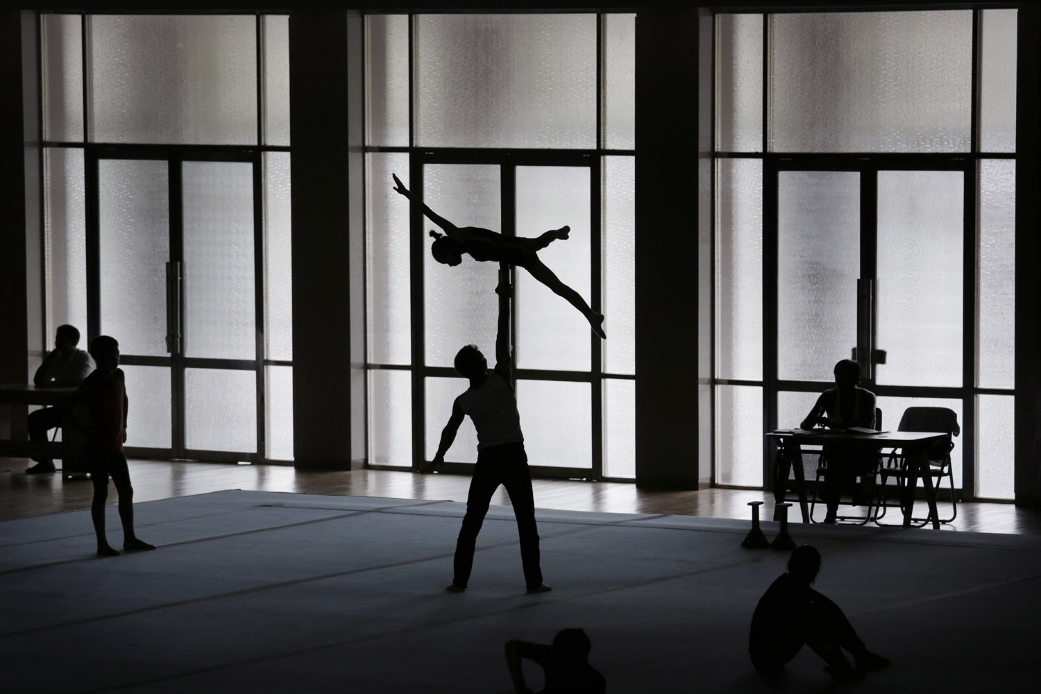 Gymnasts are silhouetted as they practice their routine in Pyongyang, Sept. 2, 2014. North Korea will soon send its top athletes to what could be the biggest sporting event of their lives and a major national propaganda campaign: the Asian Games in South Korea.