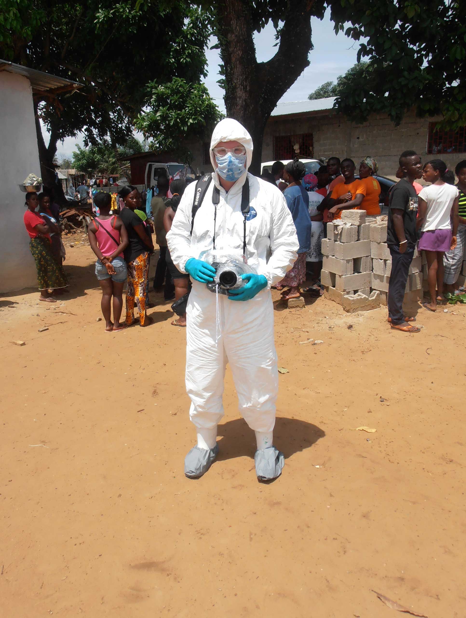 Getty Images staff photographer John Moore wears protective clothing, knows as personal protective equipment (PPE), before joining a Liberian burial team set to remove the body of an Ebola victim from her home in August 14, 2014 in Monrovia, Liberia.