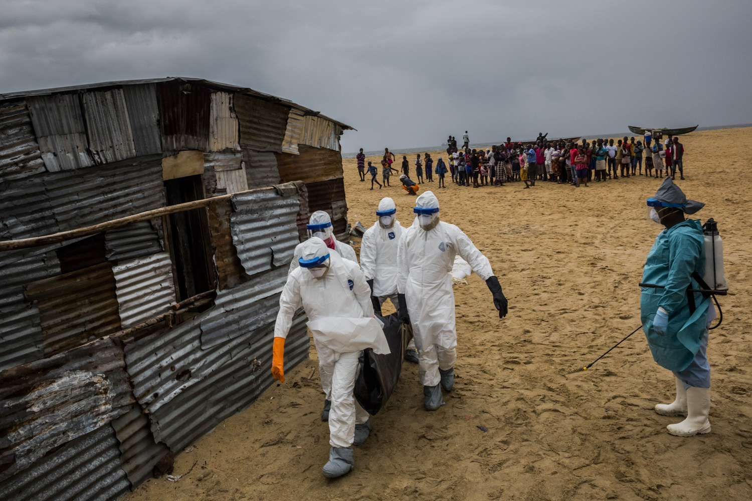 Liberian Red Cross burial team carry a body of a suspected Ebola victim from the West Point neighborhood in Monrovia, Liberia, Sept. 17, 2014. (Daniel Berehulak/The New York Times/Redux)