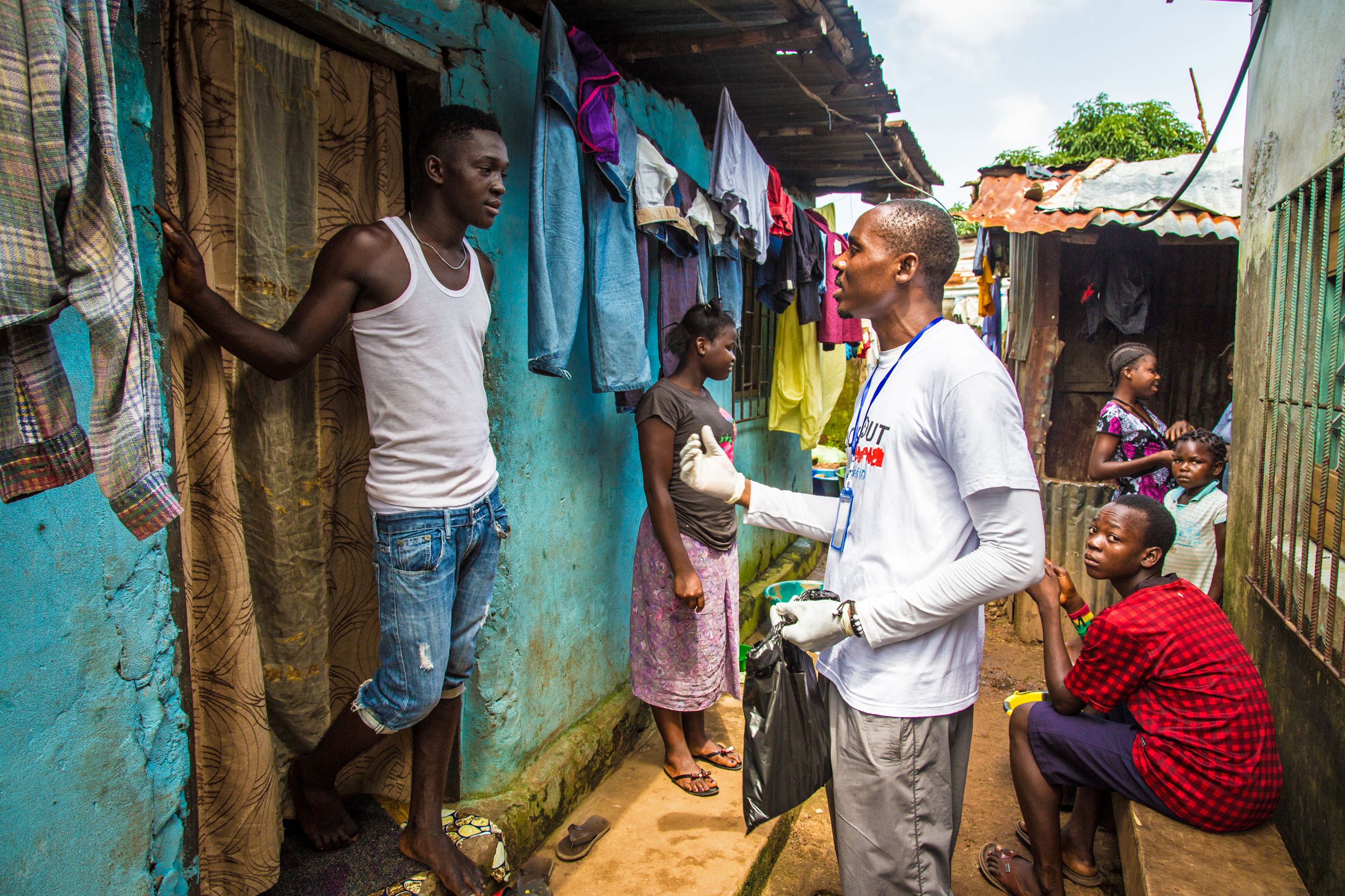 A volunteer health worker talks with a resident on how to prevent and identify the Ebola virus in others, and distributes bars of soap in Freetown, Sierra Leone, Sept. 20, 2014. (Michael Duff—AP)
