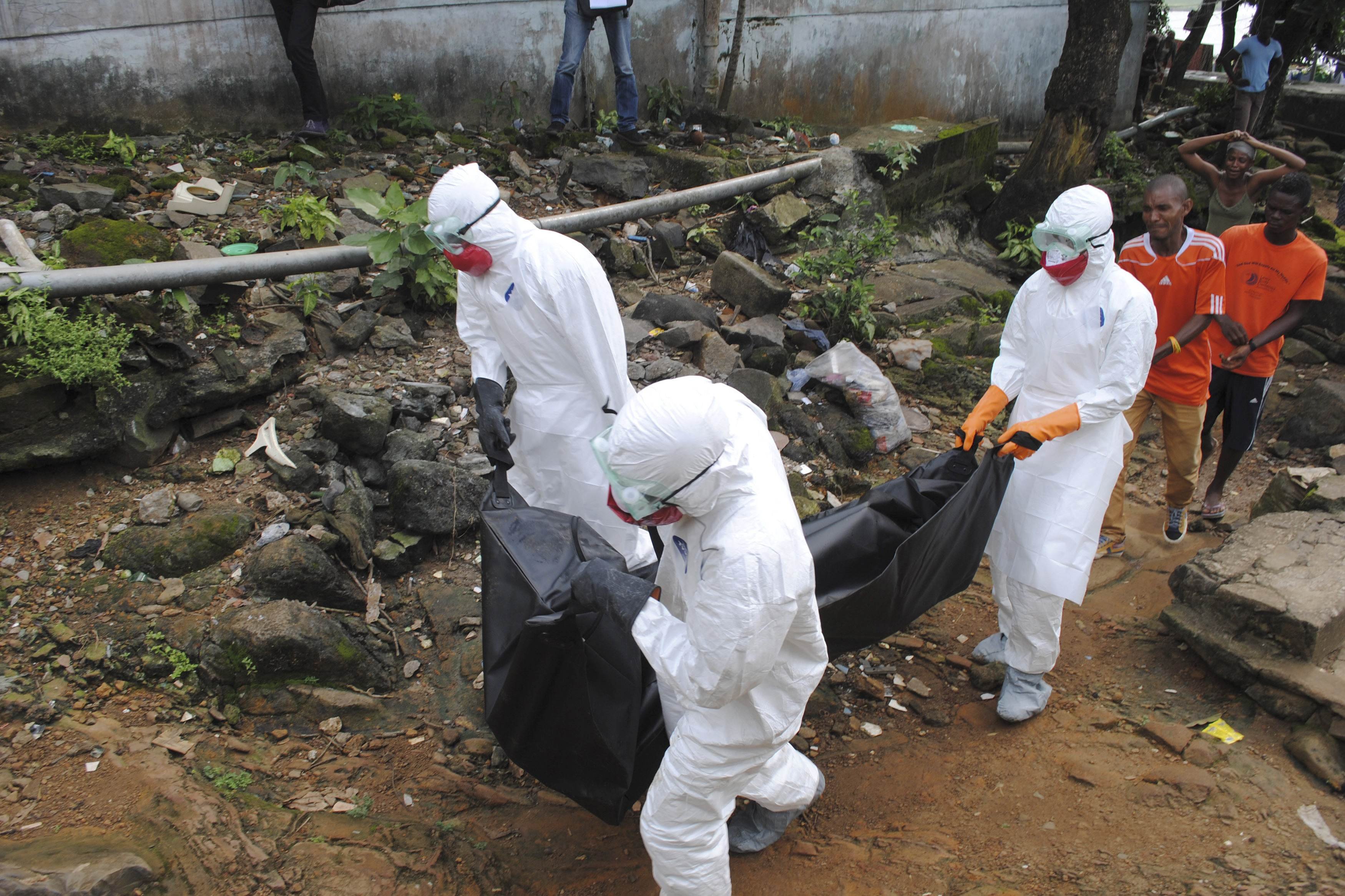 Health workers remove the body of Prince Nyentee, a man whom local residents said died of Ebola virus in Monrovia