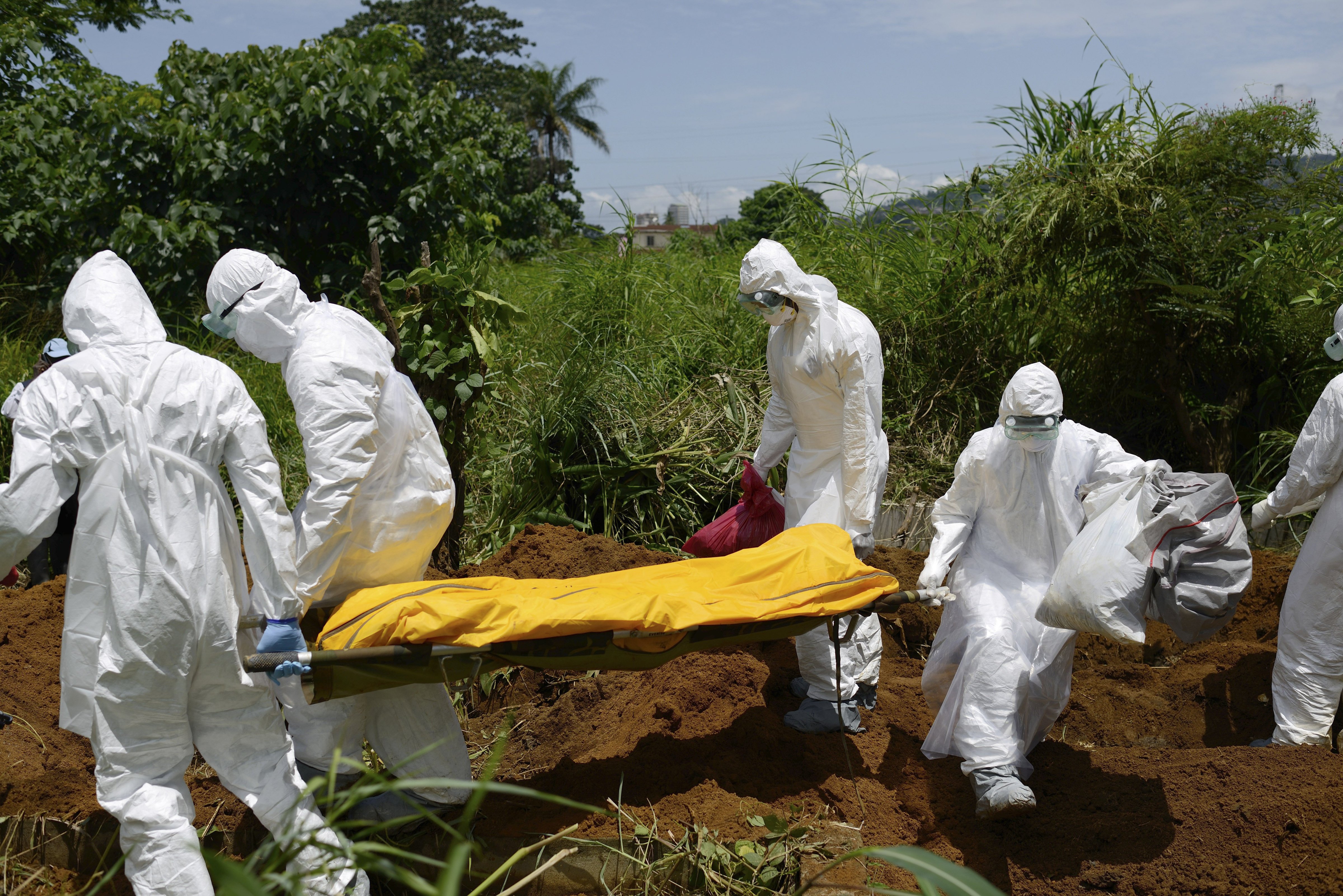 Members of a burial team wearing protective suits bury an Ebola victim in Freetown, Sierra Leone.